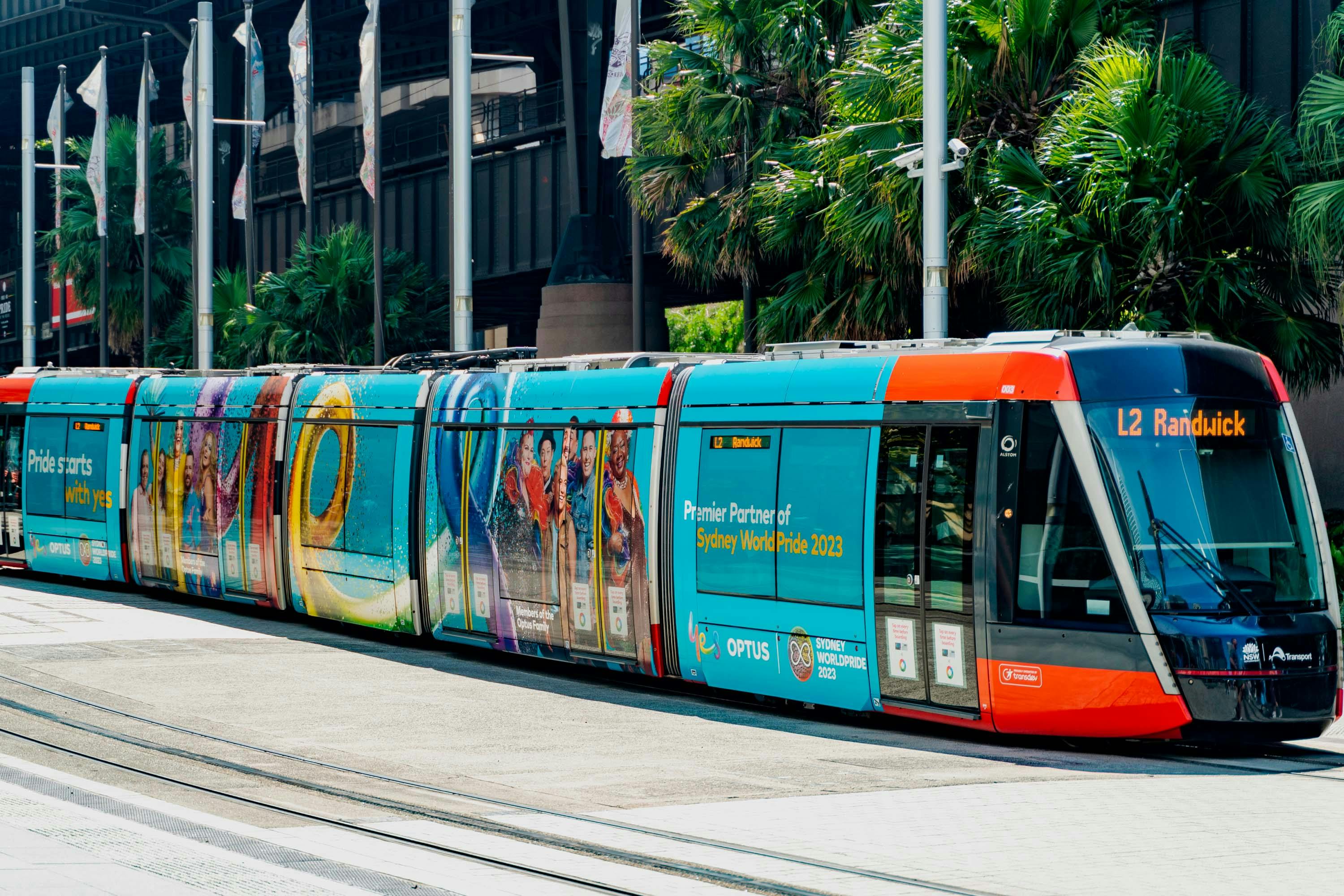 A photo of the Sydney light rail featuring the Optus x SydneyWorldPride campaign: Pride starts with yes