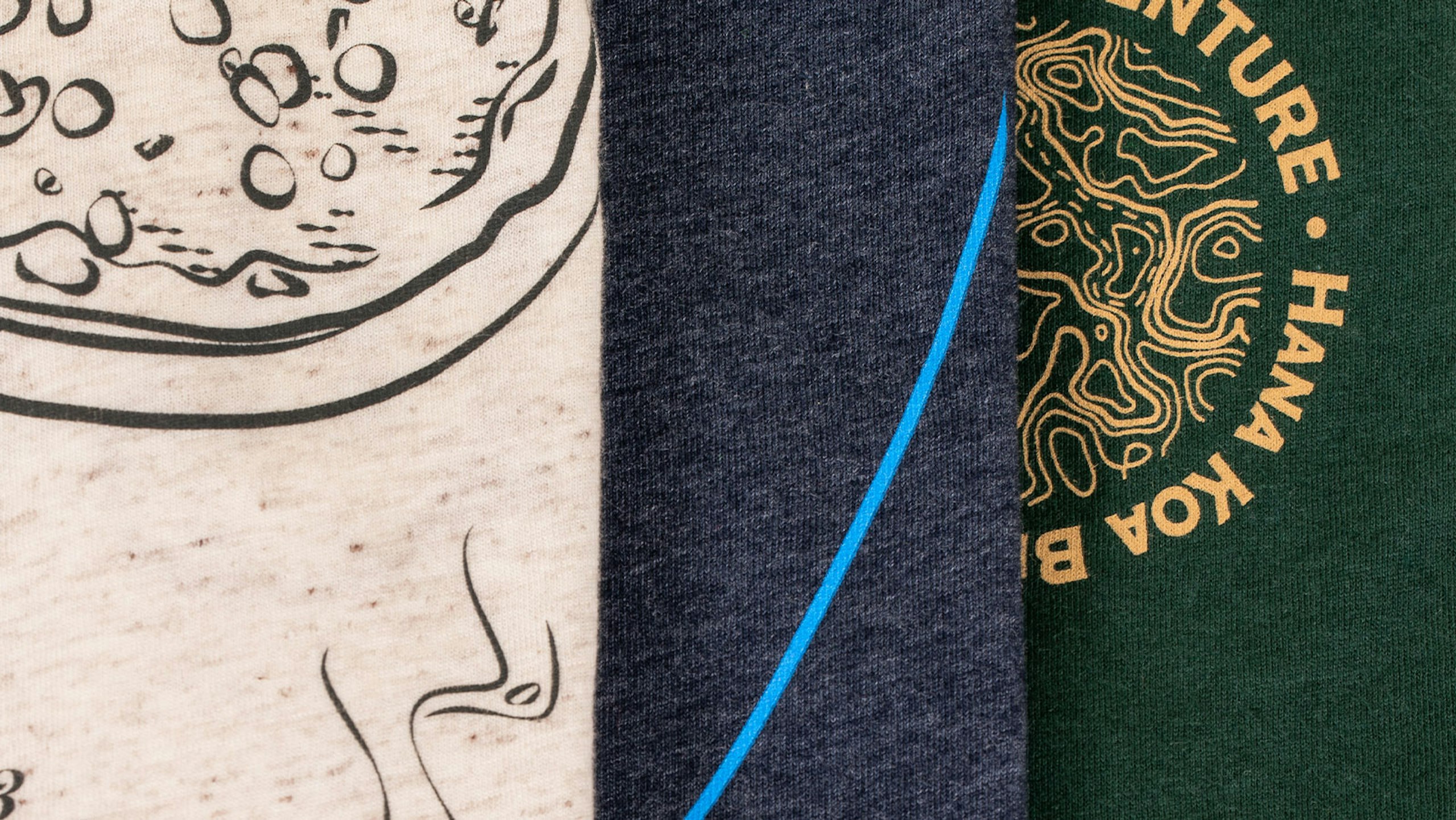 Close-up of three shirts. Left oat white, middle navy, and right dark green.