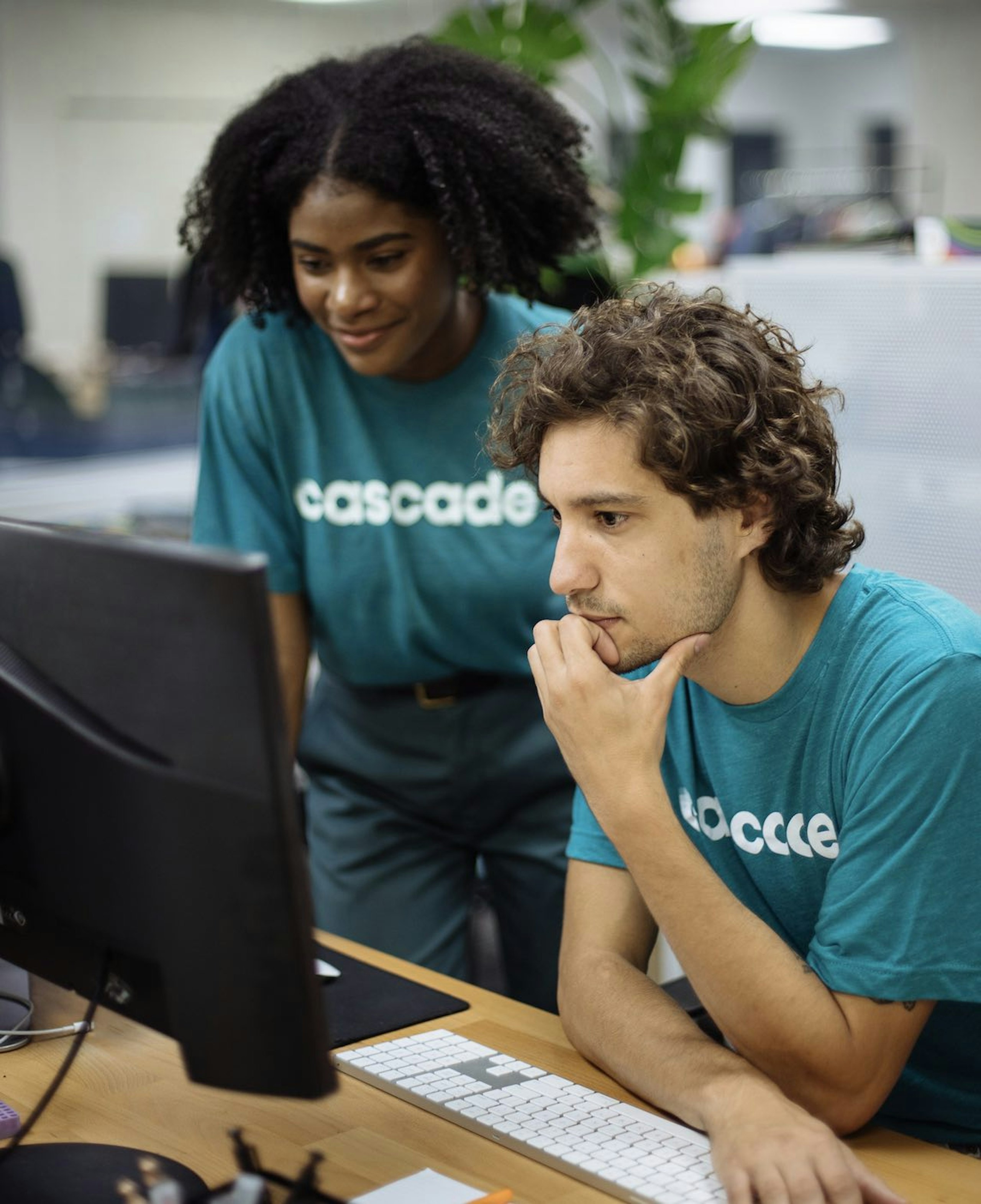 A woman and a man work together while wearing matching t-shirts for their company
