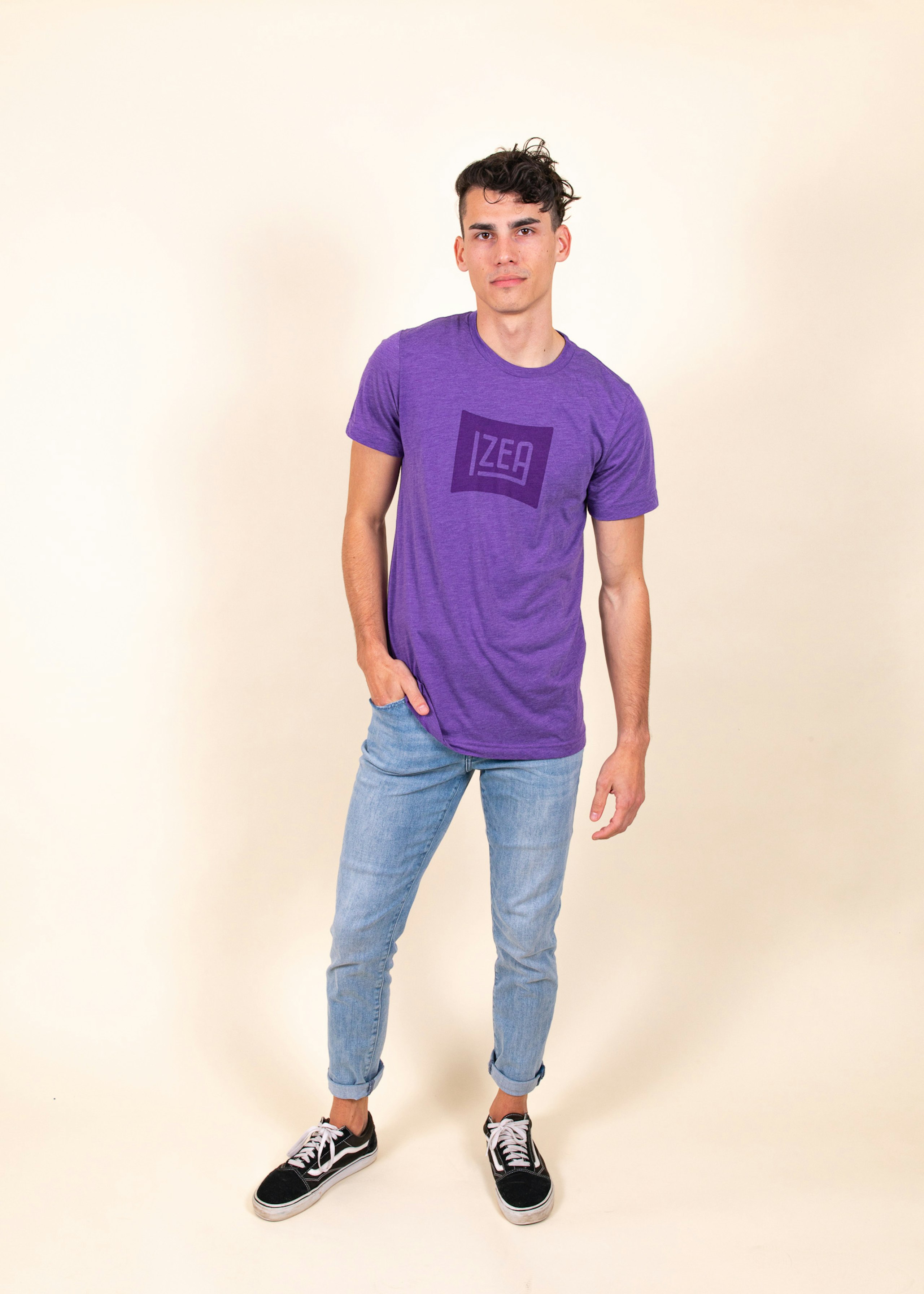 Man wearing purple t-shirt with tonal dark printing  that says "Izea"
