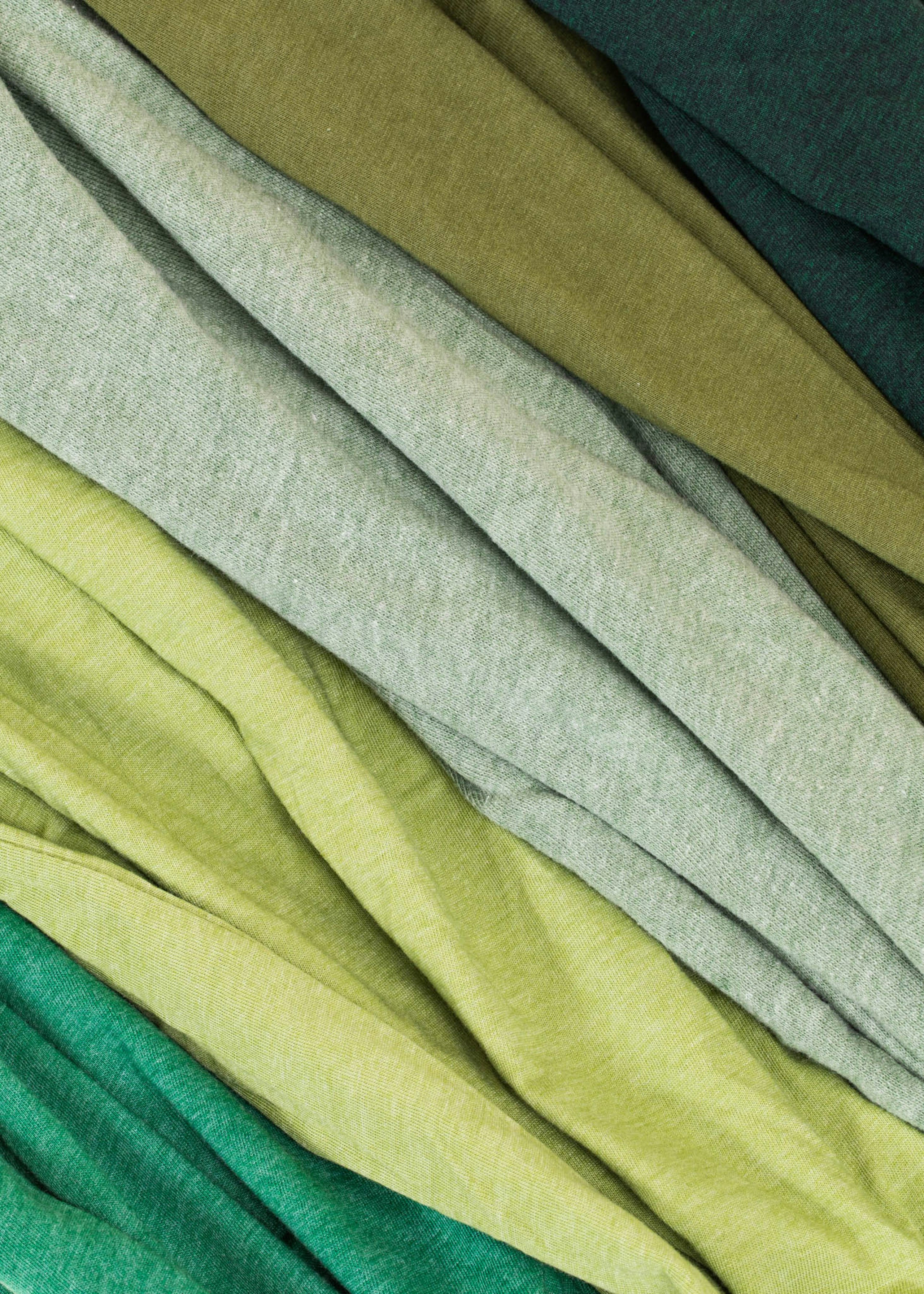 a stack of multiple green fabrics next to each other