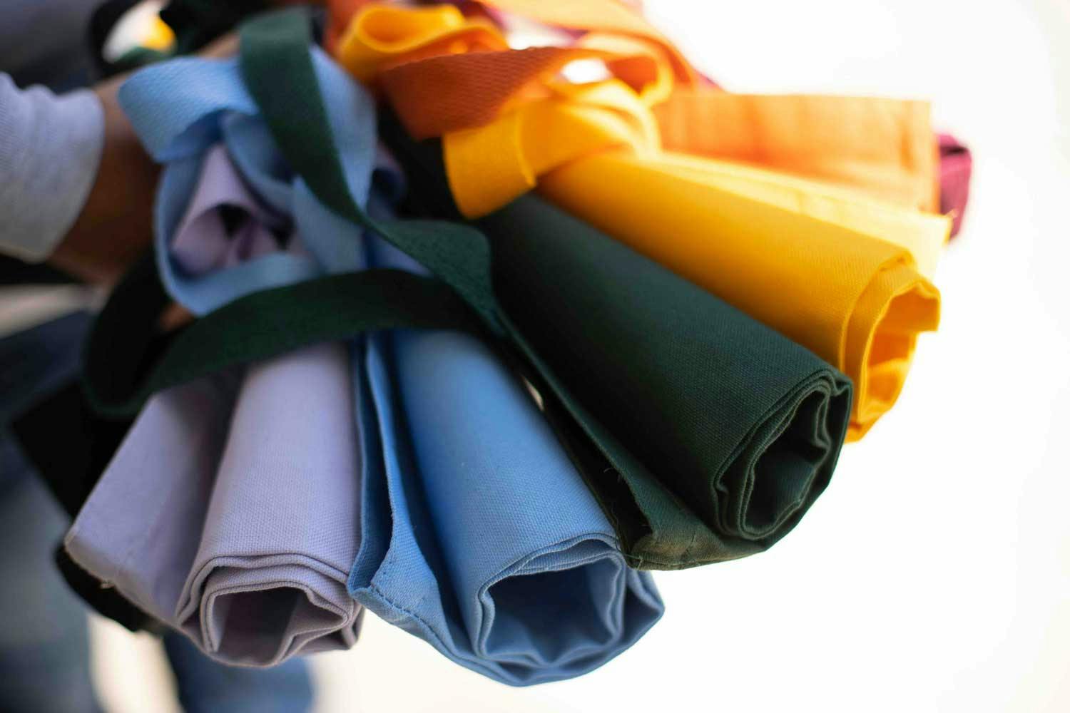 purple, blue, green, and yellow rolled totes