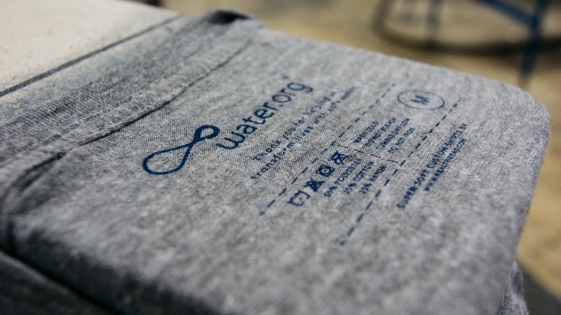 close up of a printed tag being added to a gray shirt