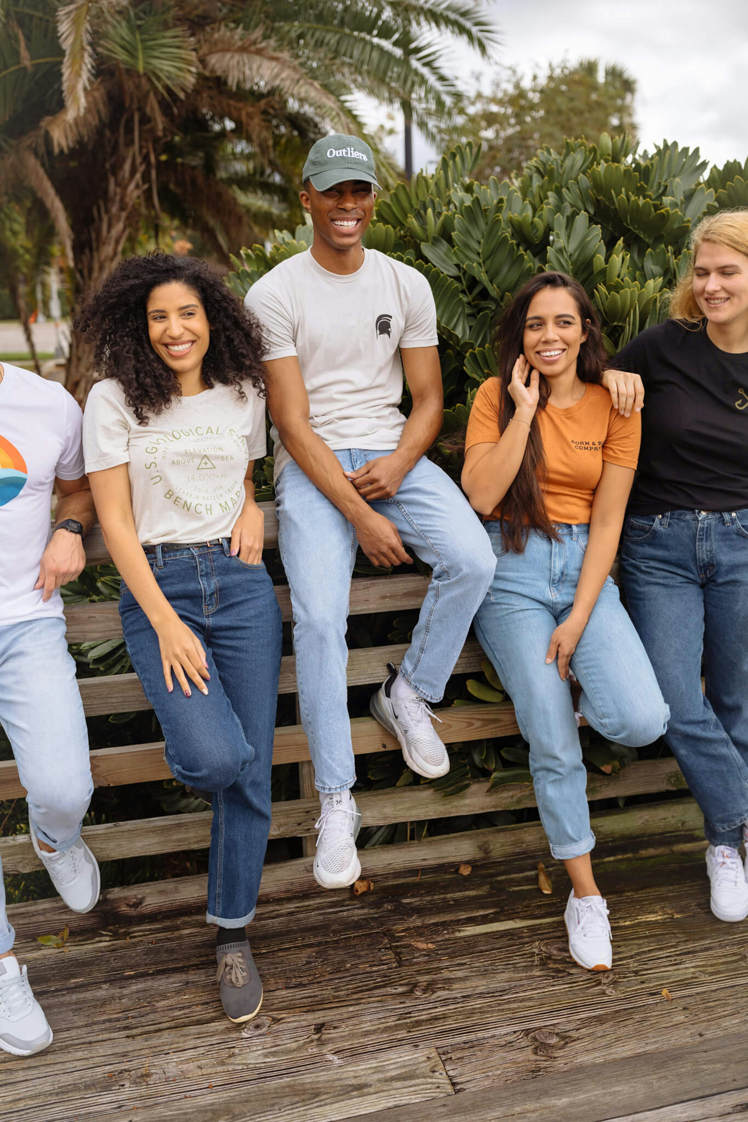 A group of people all wearing custom t-shirts sitting on a dock