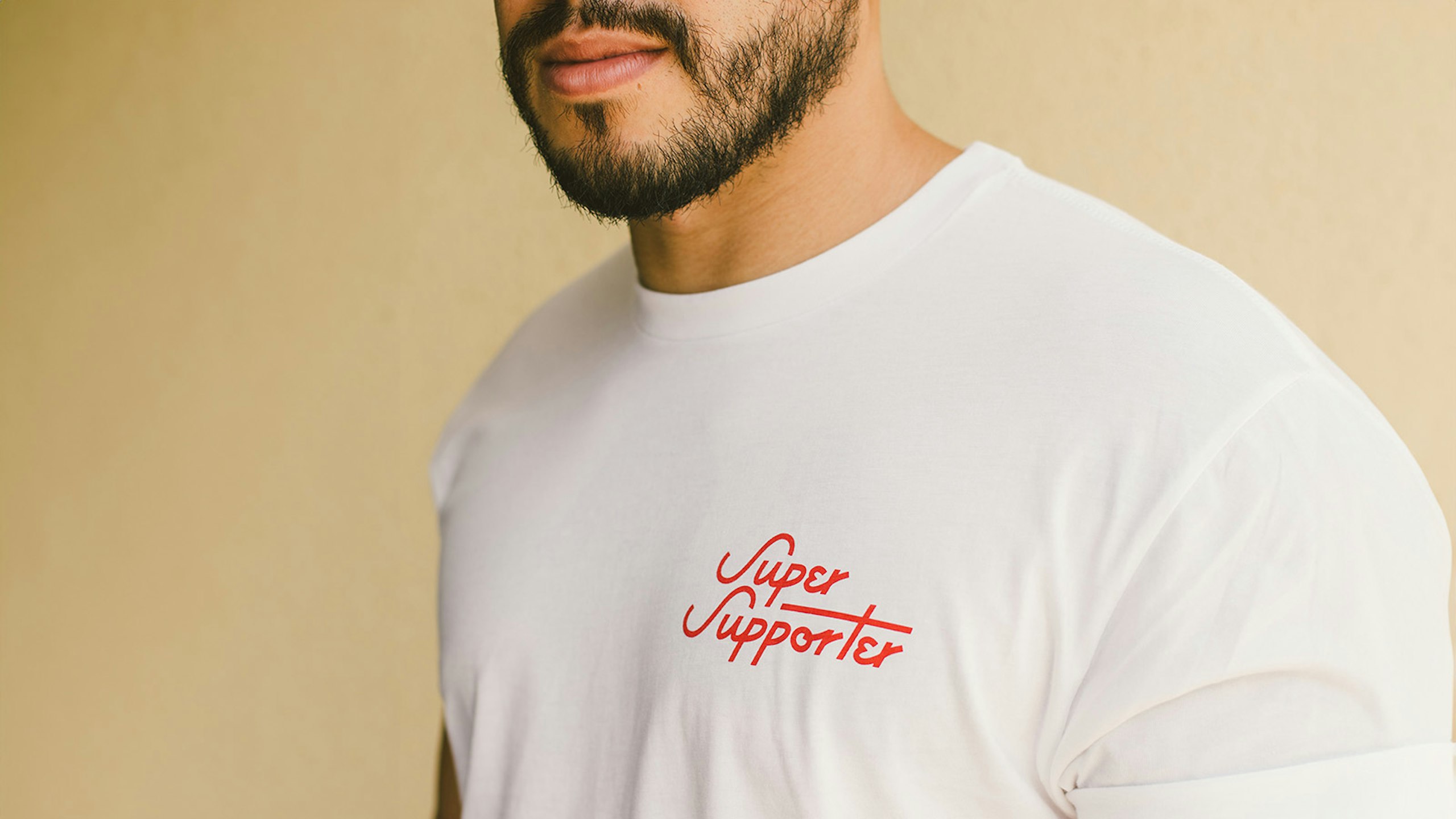 man wearing a white shirt with Super Supporter printed in red