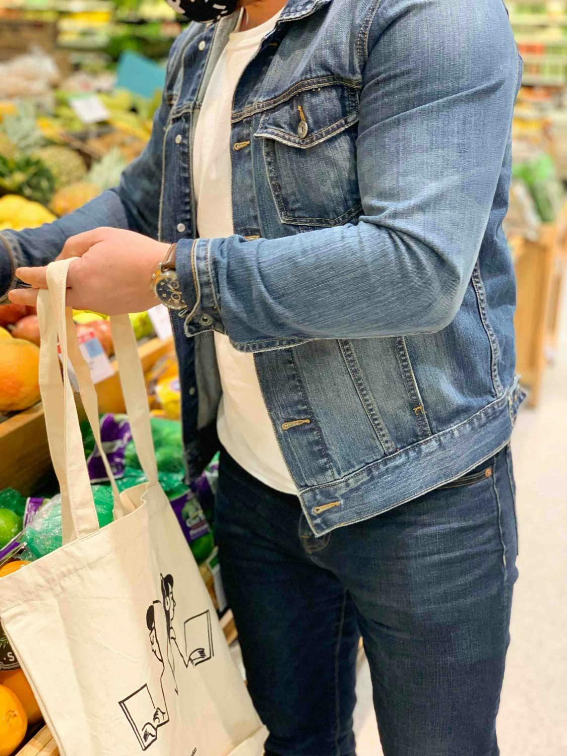 someone using a tote bag while they shop for food