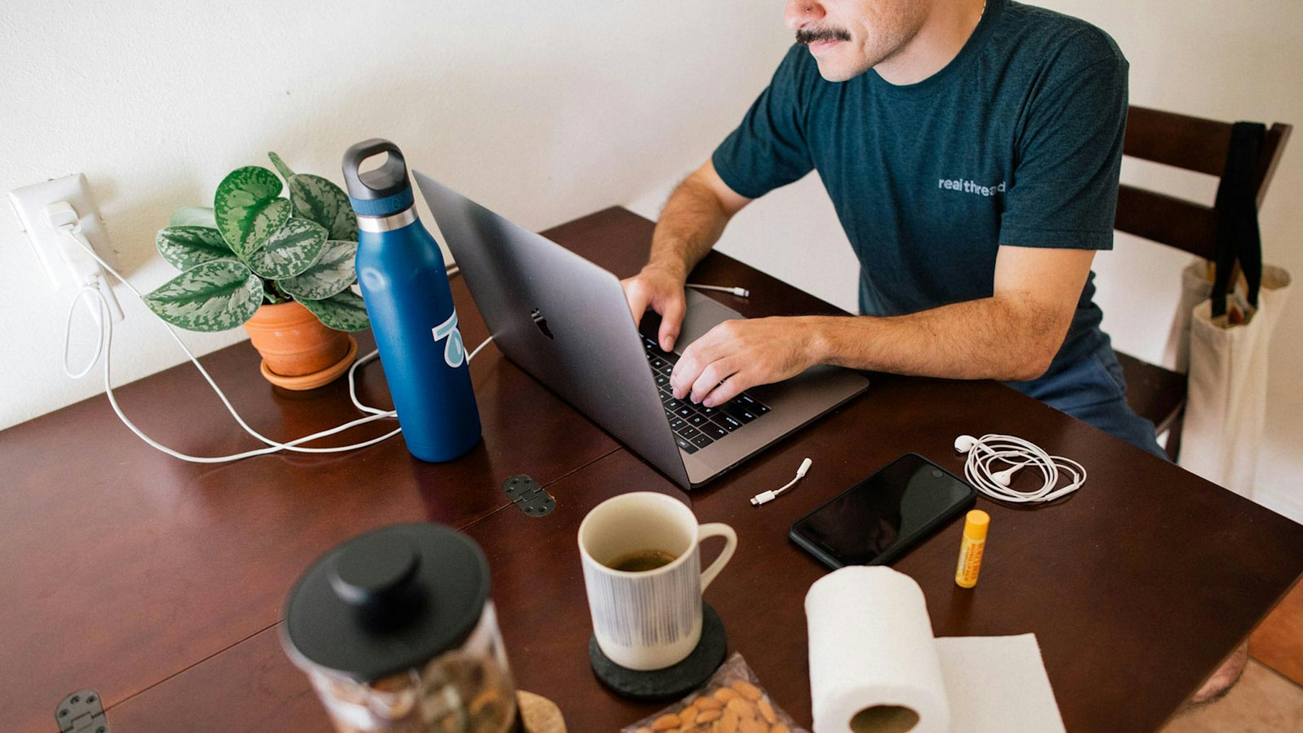 man sitting at a dinning room table with a laptop