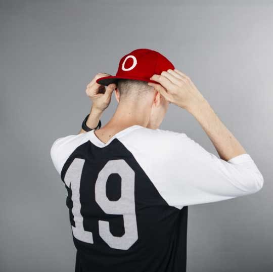 man wearing baseball hat pulling the red brim down man wearing baseball hat pulling the red brim down