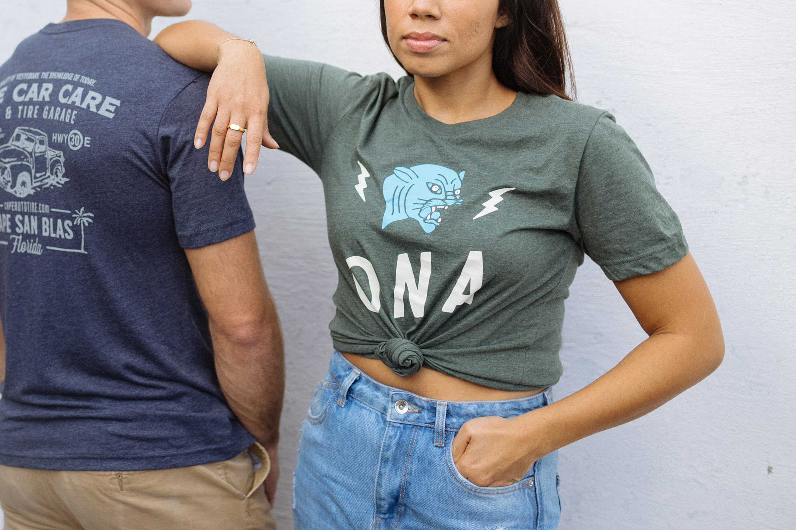 women wearing a green t-shirt with her arm on the should of a man wearing a navy shirt