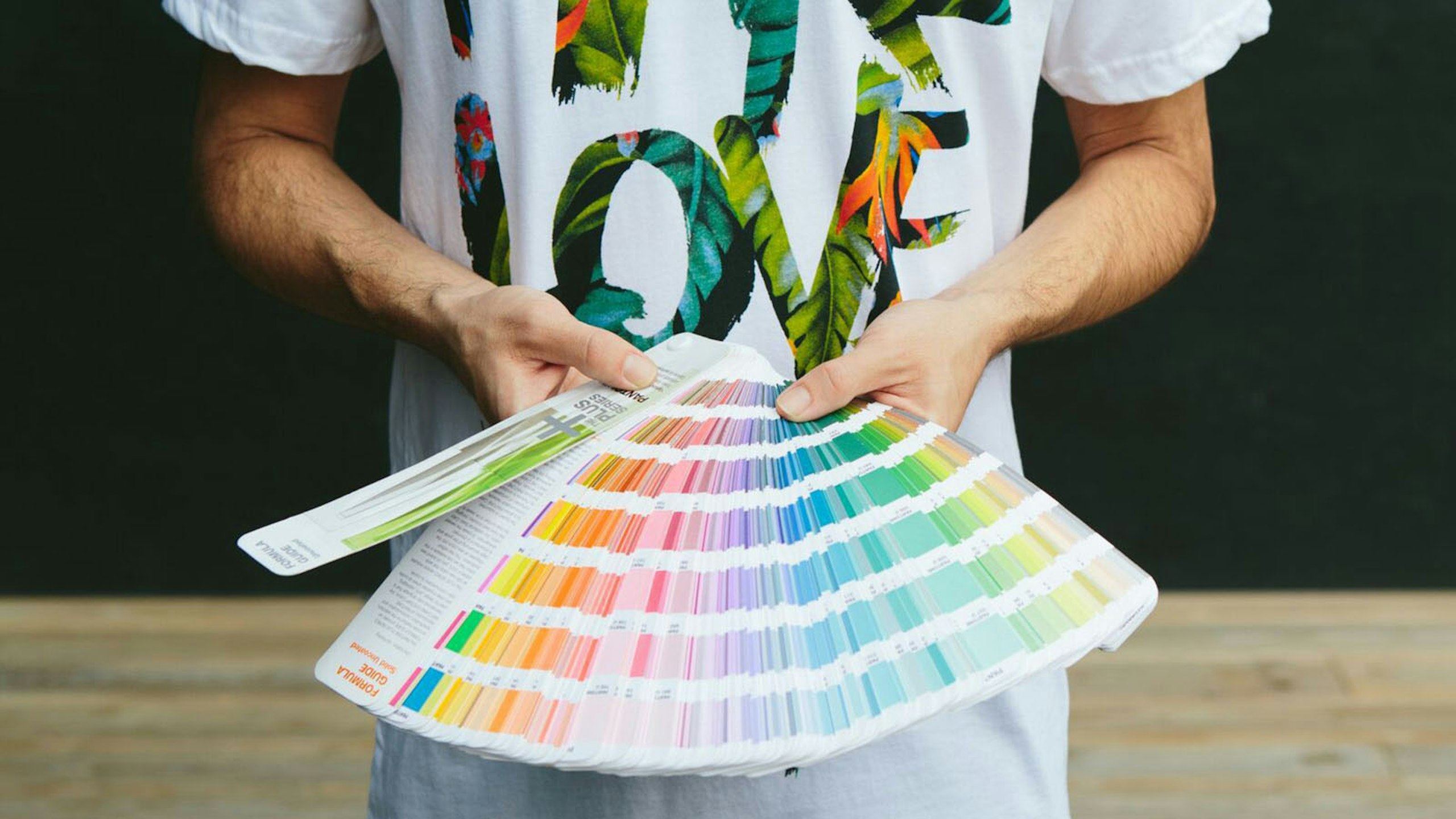person holding a pantone book fanned out
