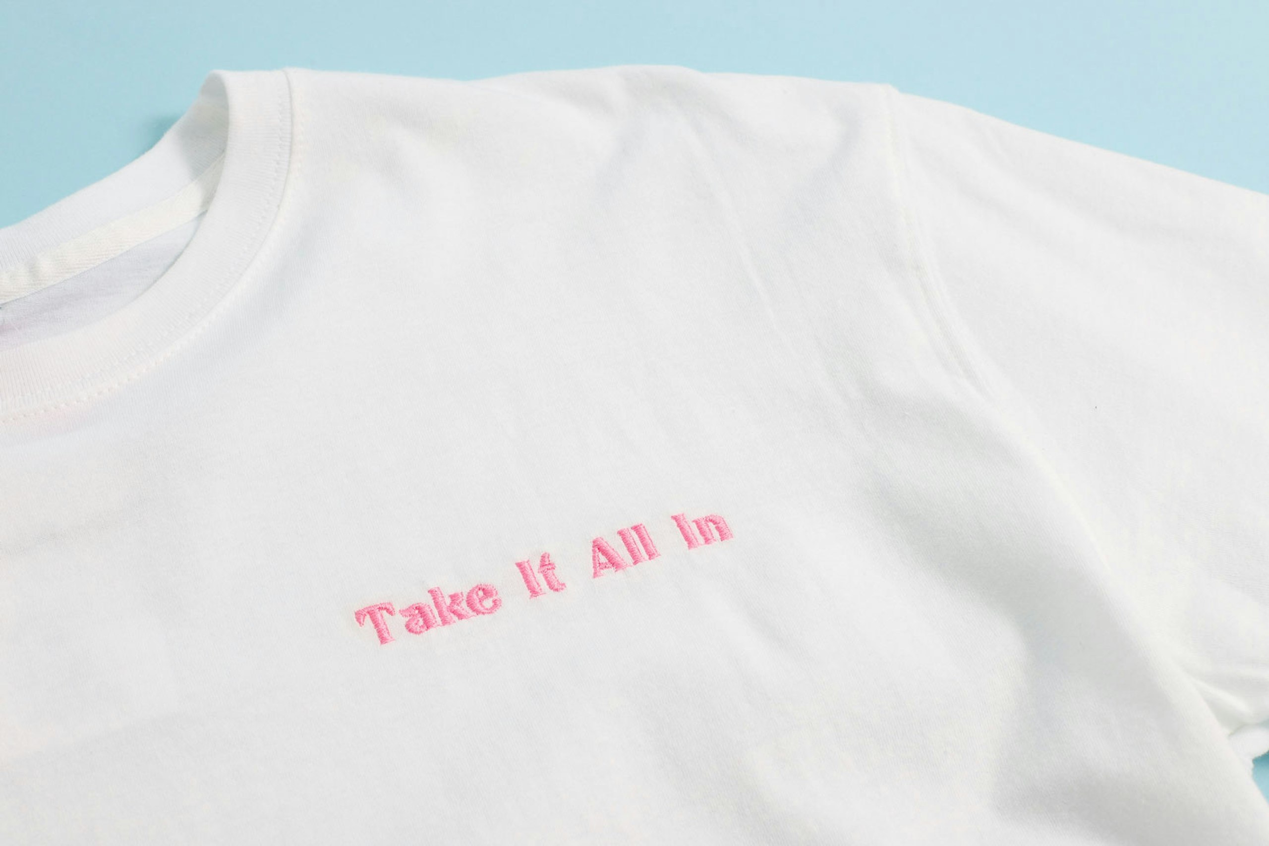 white shirt with prink embroidered words