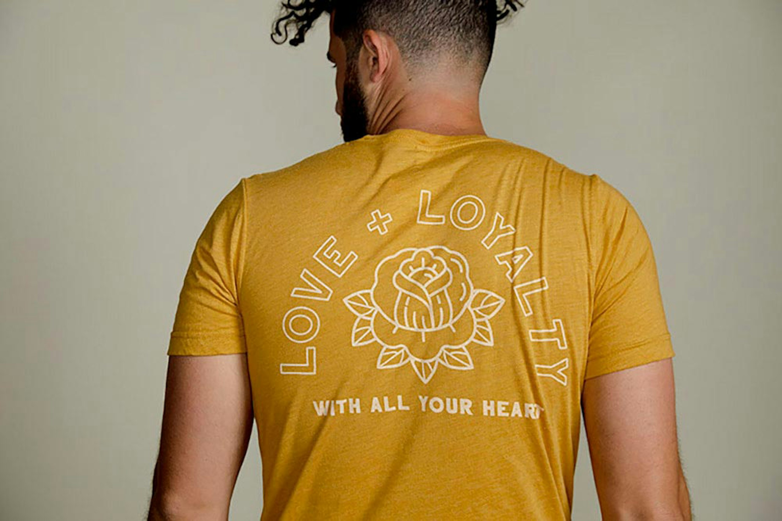 man wearing yellow shirt facing his back