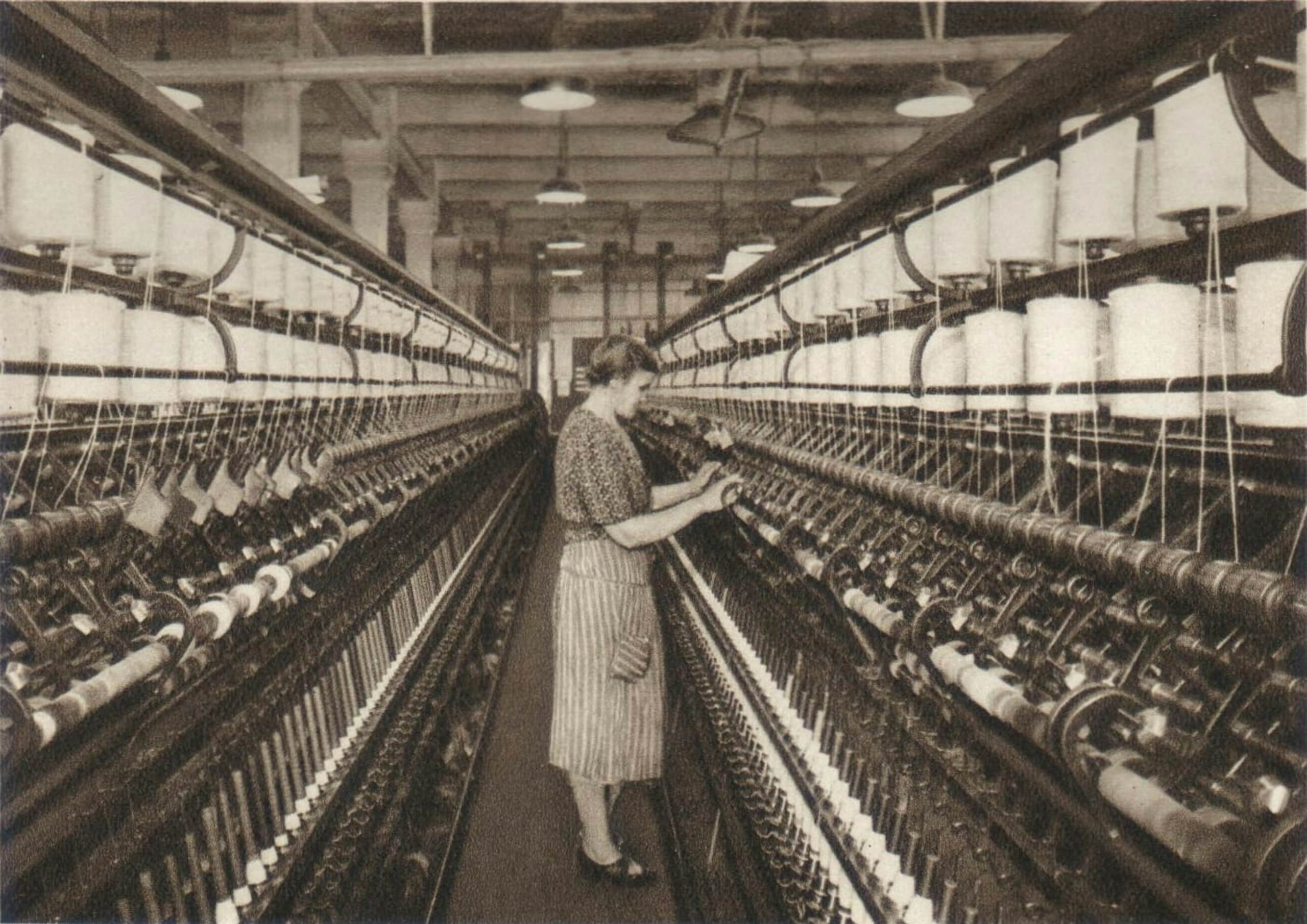 black and white photo of a women in a textile factory