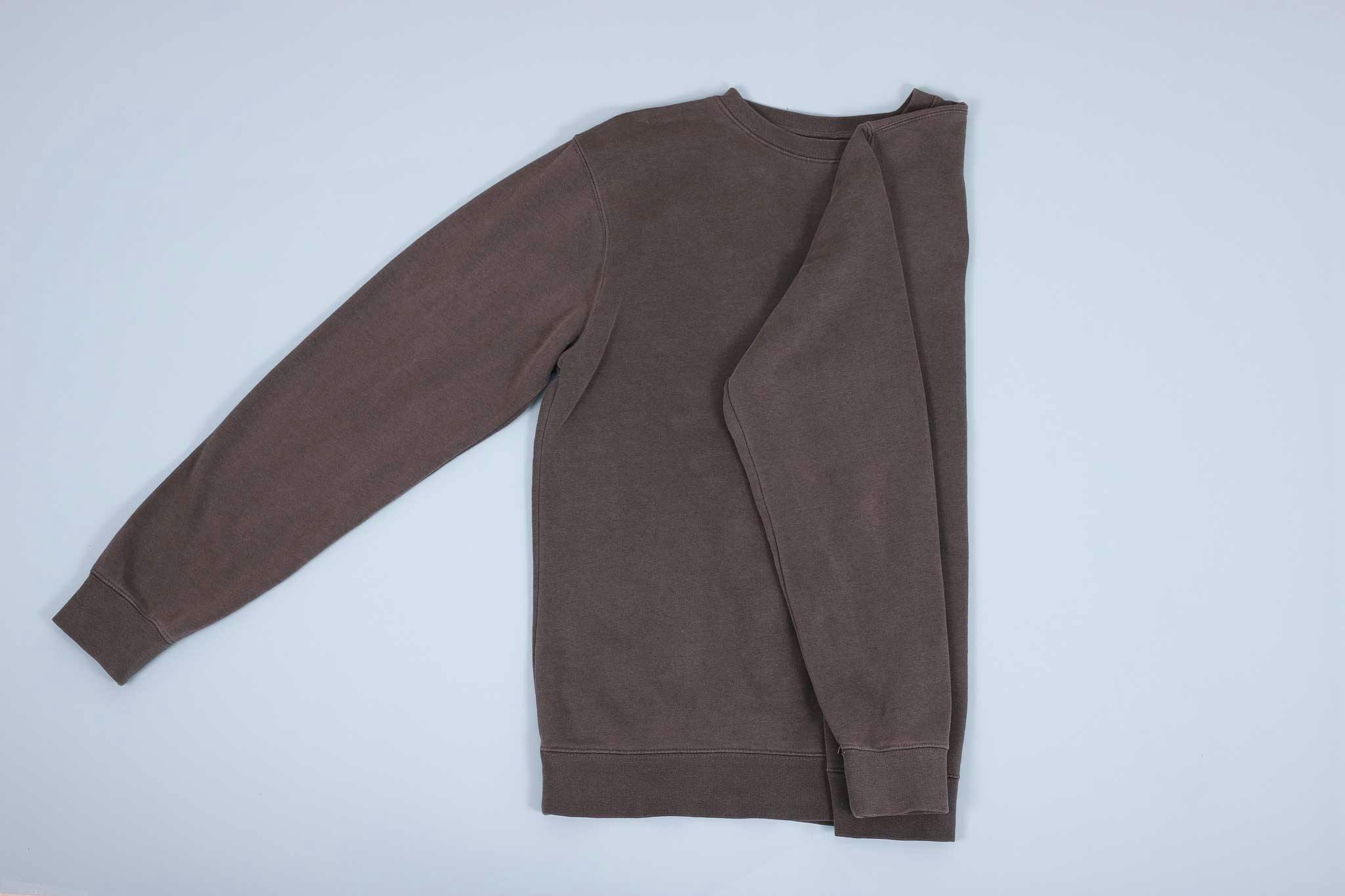 Grey sweater with sleeve folded in and then down towards the hem Grey sweater with sleeve folded in and then down towards the hem