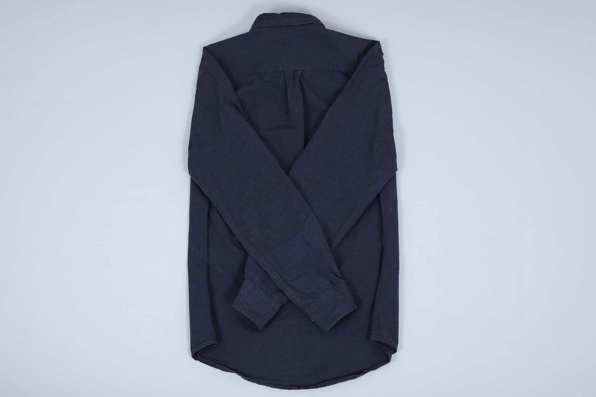 Navy buttoned up shirt with both sleeves crossed over each other on the back Navy buttoned up shirt with both sleeves crossed over each other on the back