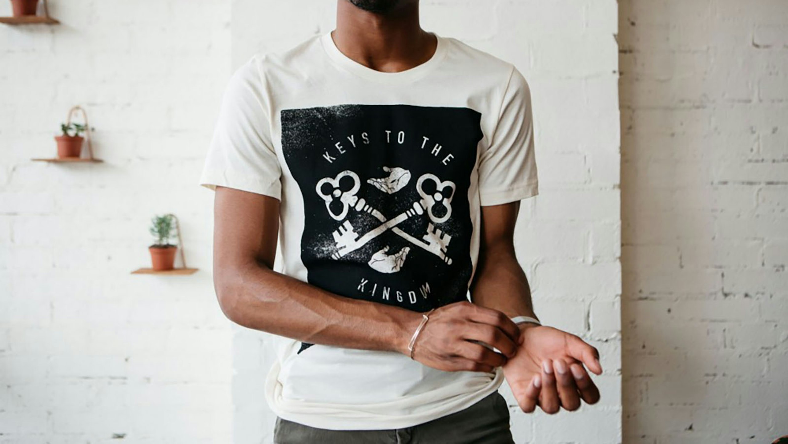 man wearing a white shirt with a large black print on the front