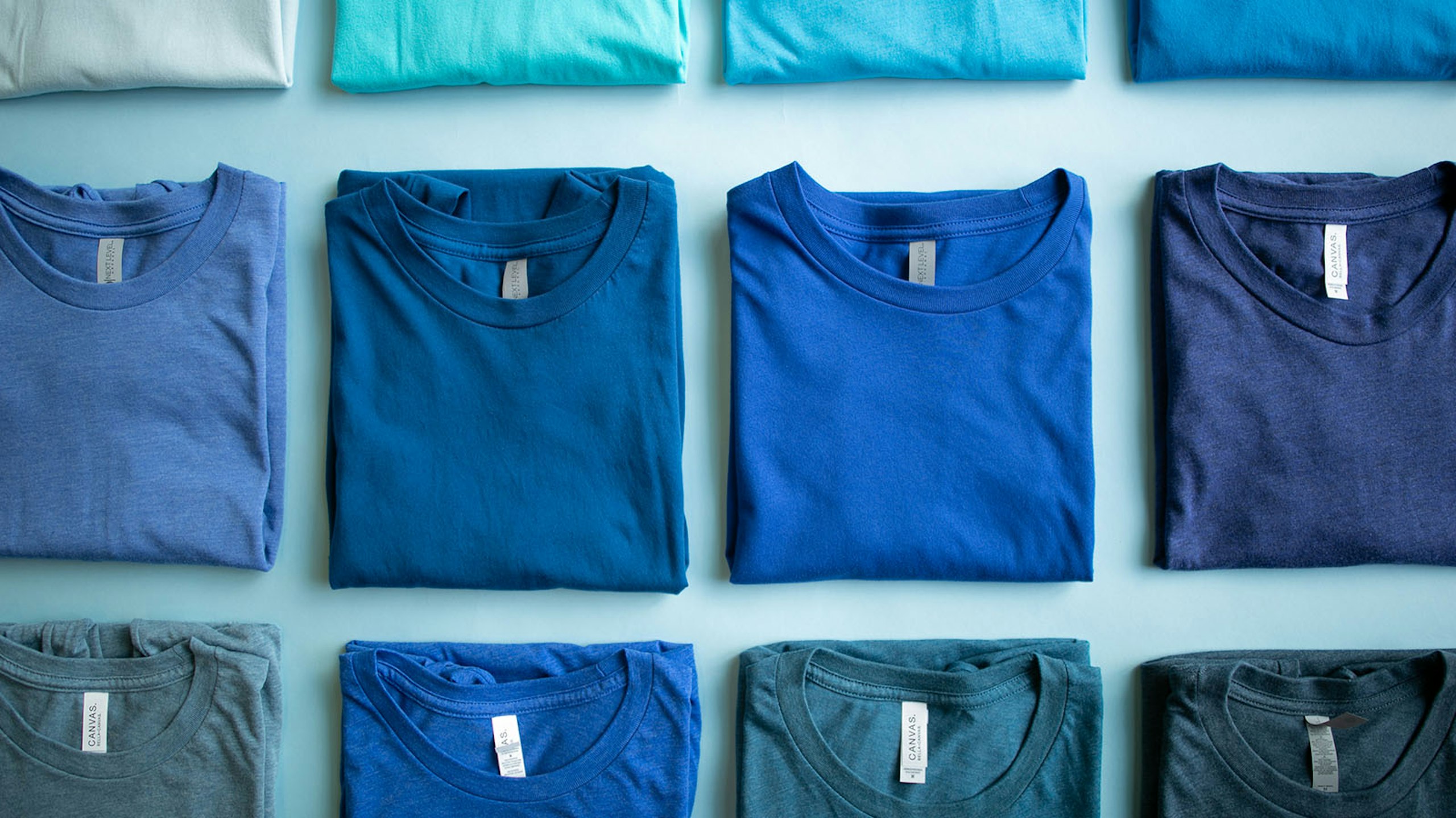 collection of blue t-shirts folded