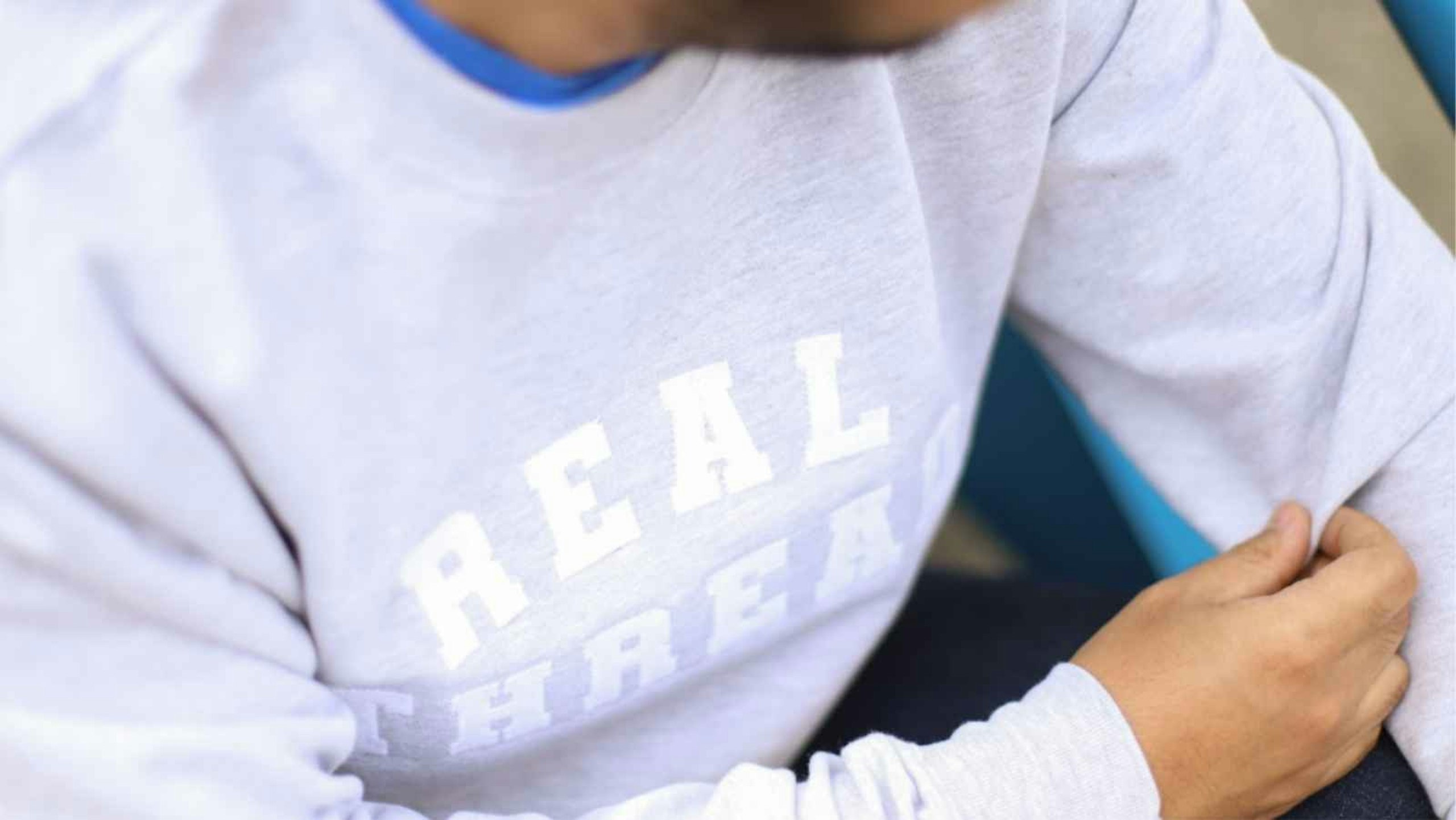 white "real thread" printed on gray sweatshirt
