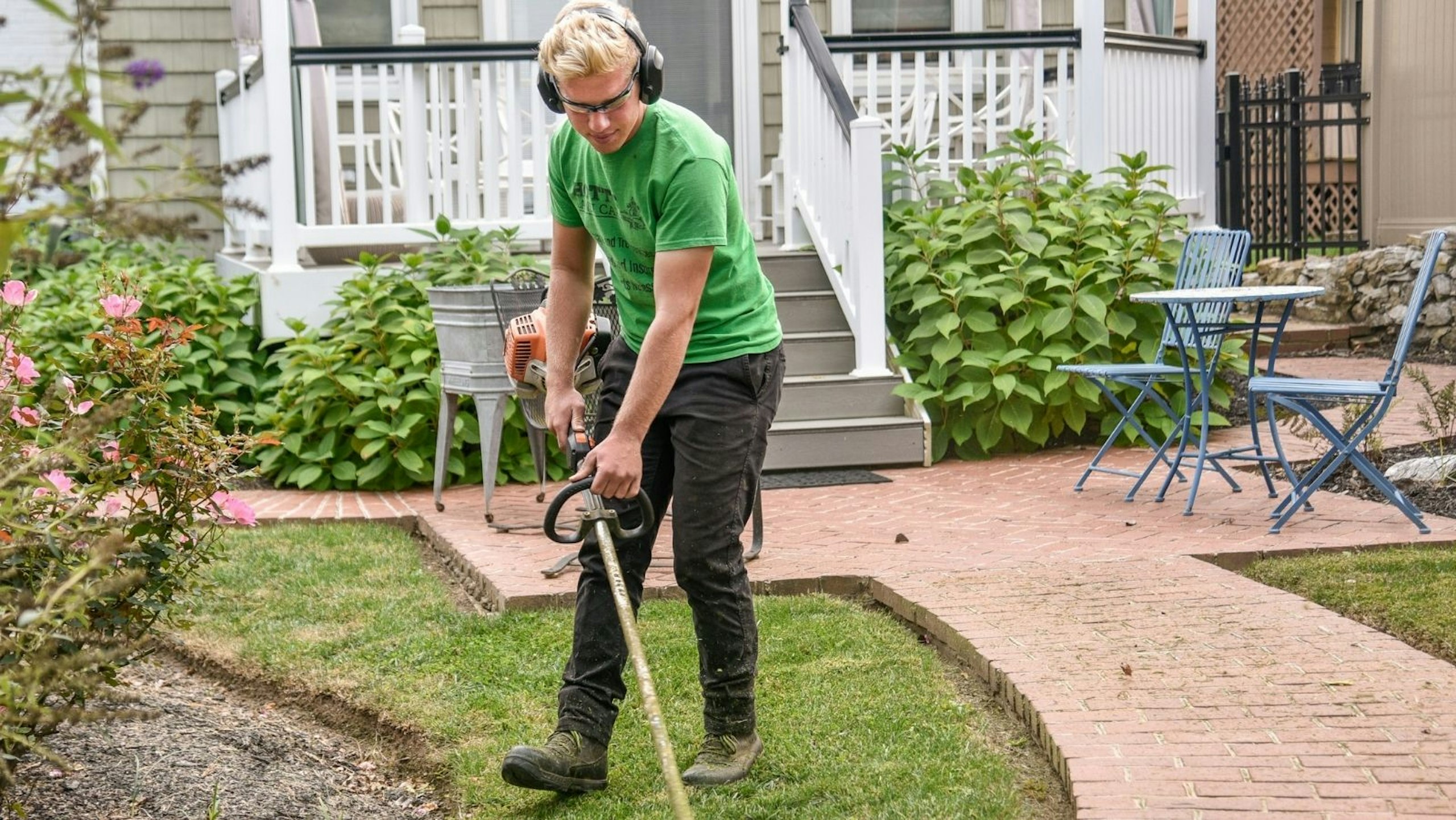 person edge trimming their backyard