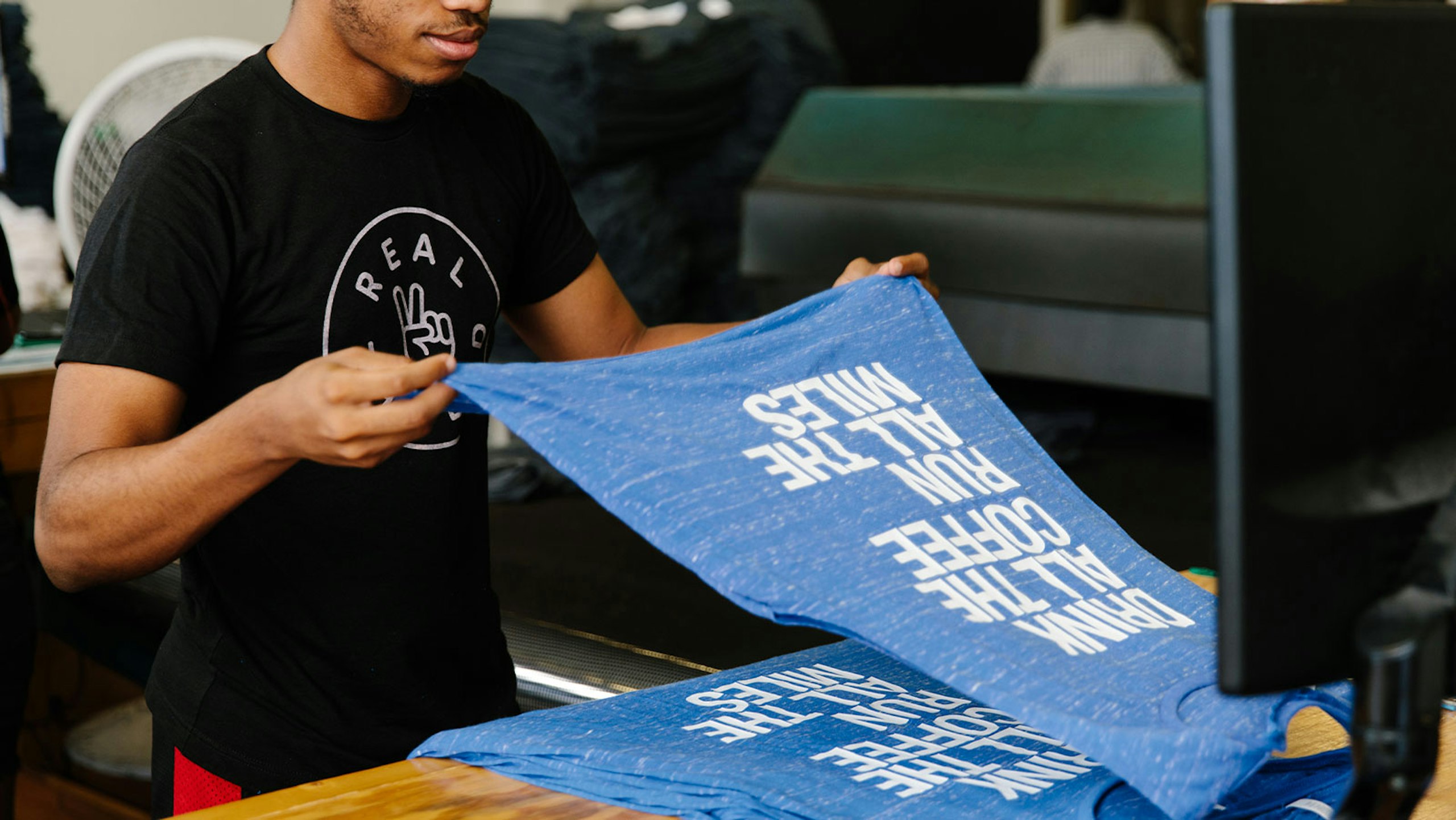 someone stacking blue t-shirts