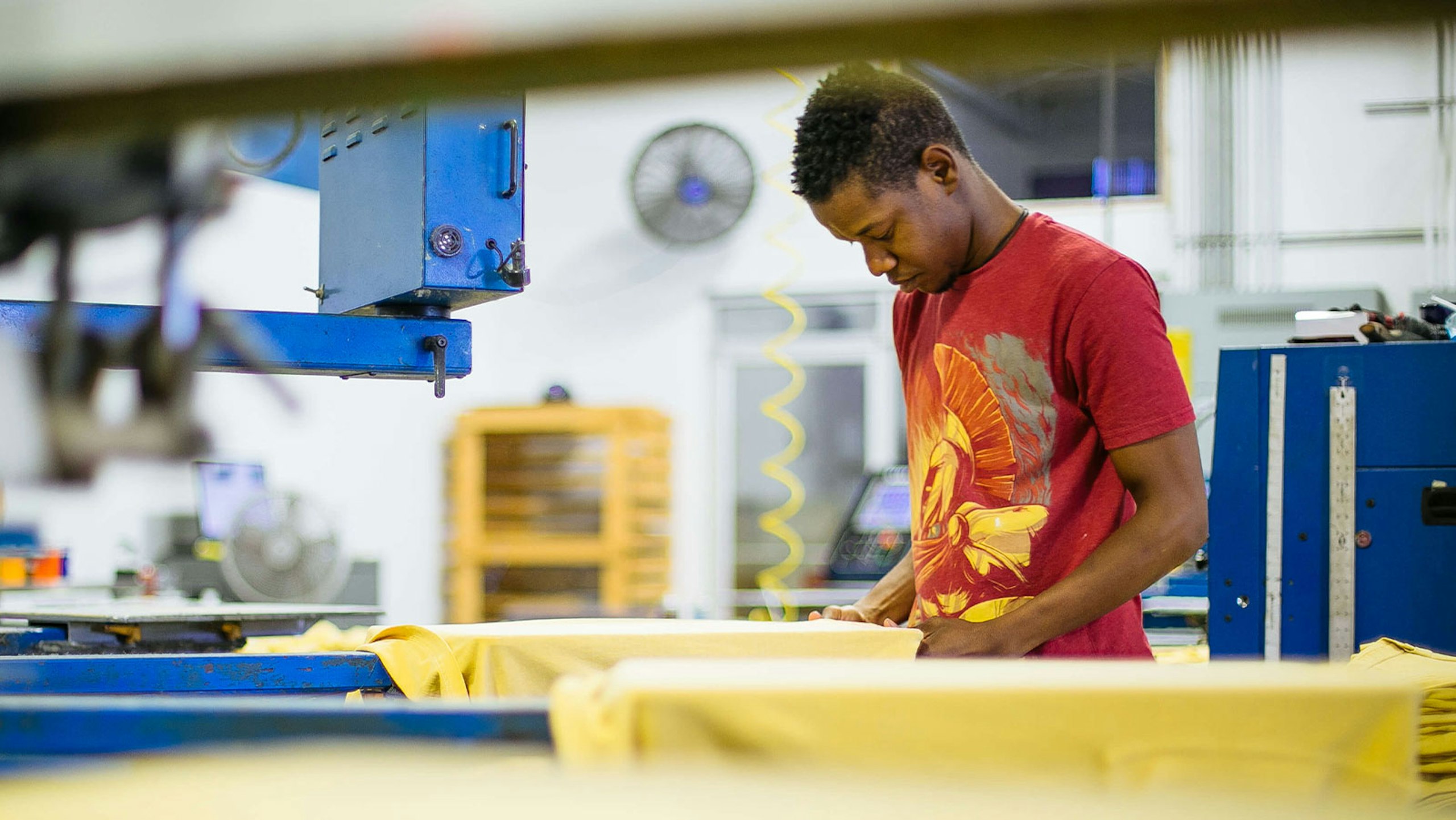 man loading t-shirts on a printing press