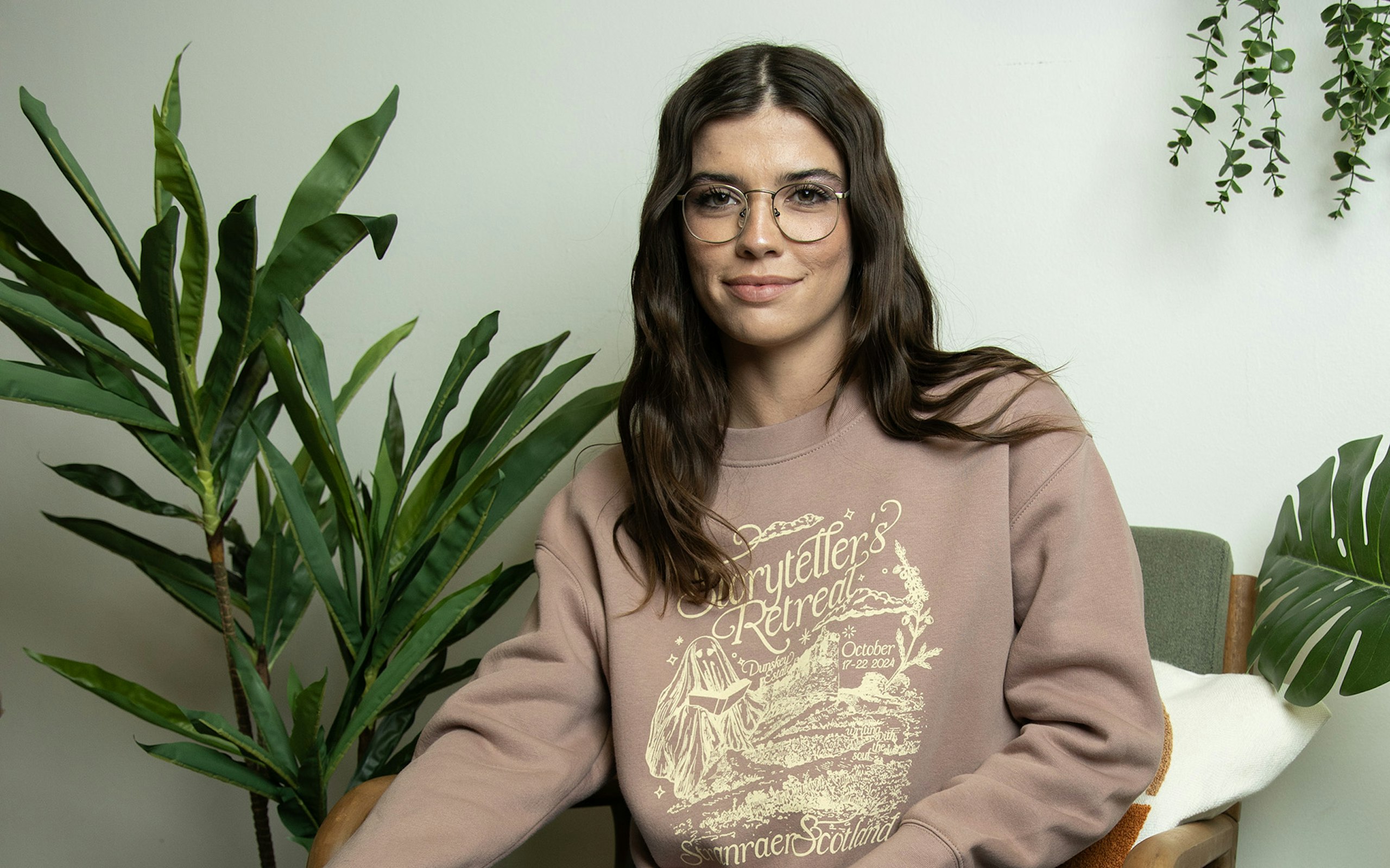 women wearing a dusty pink crewneck sweatshirt with a yellow-white print