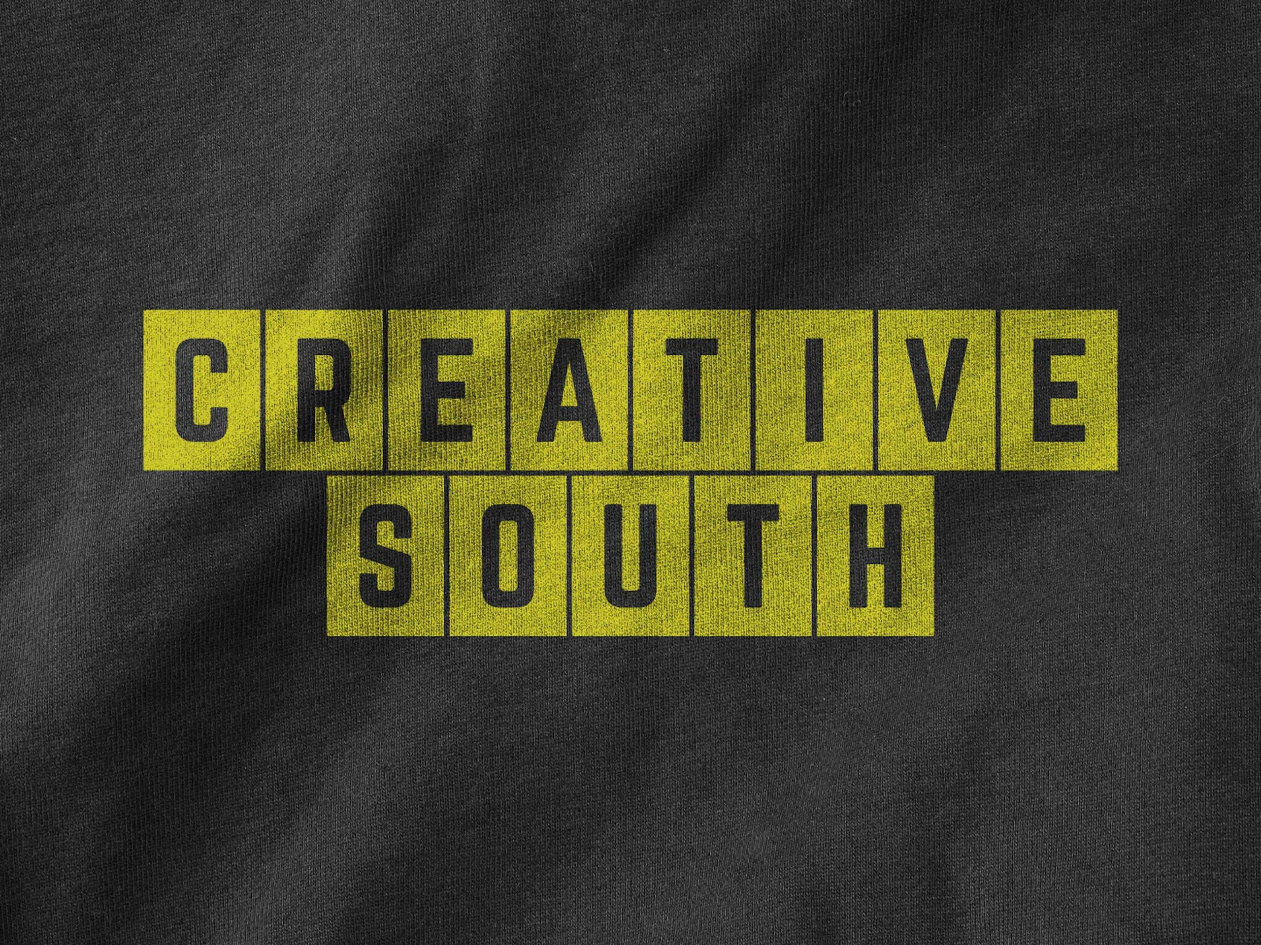 yellow creative south 2025 logo on t-shirt fabric texture