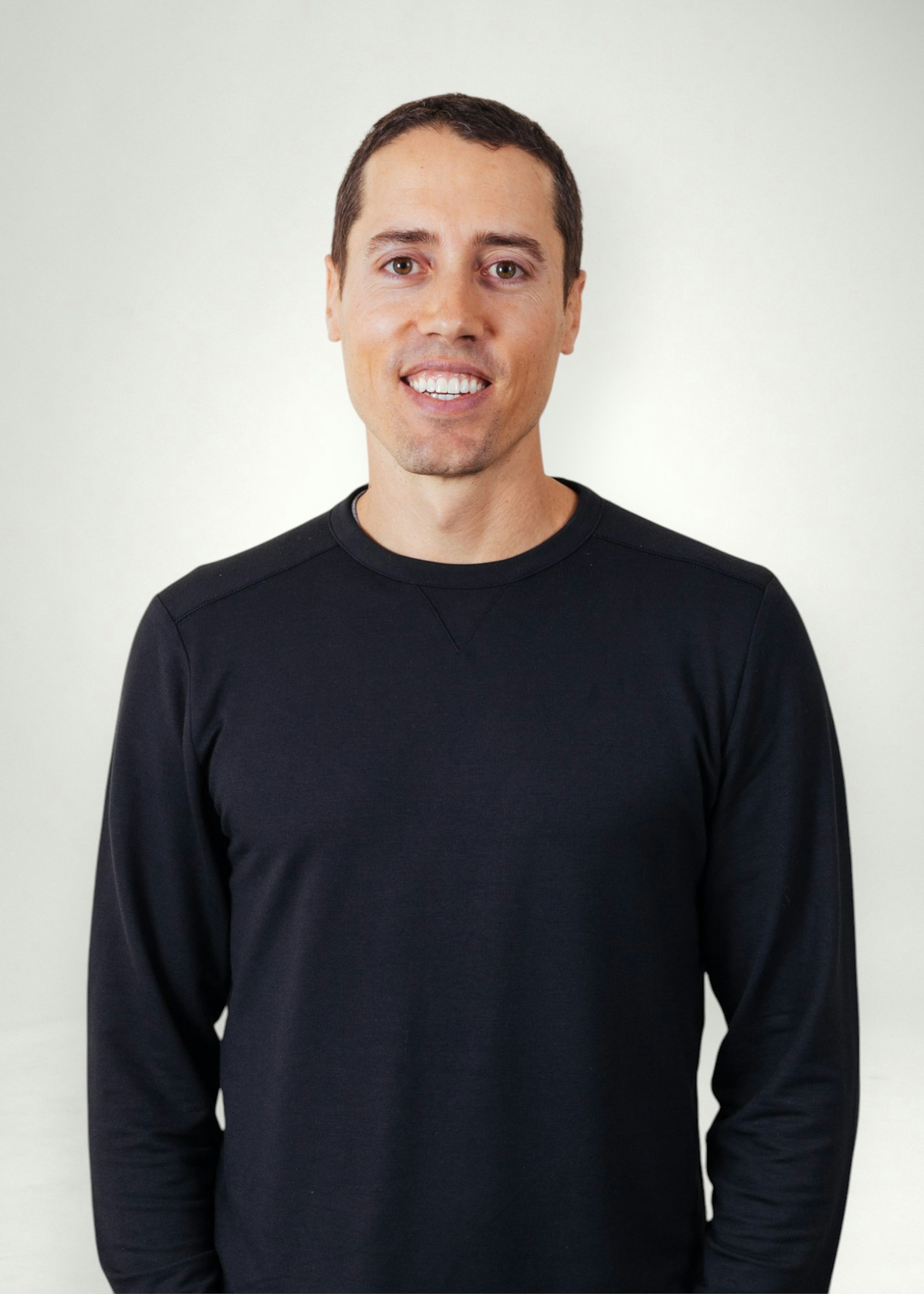 Dru poses in front of white background