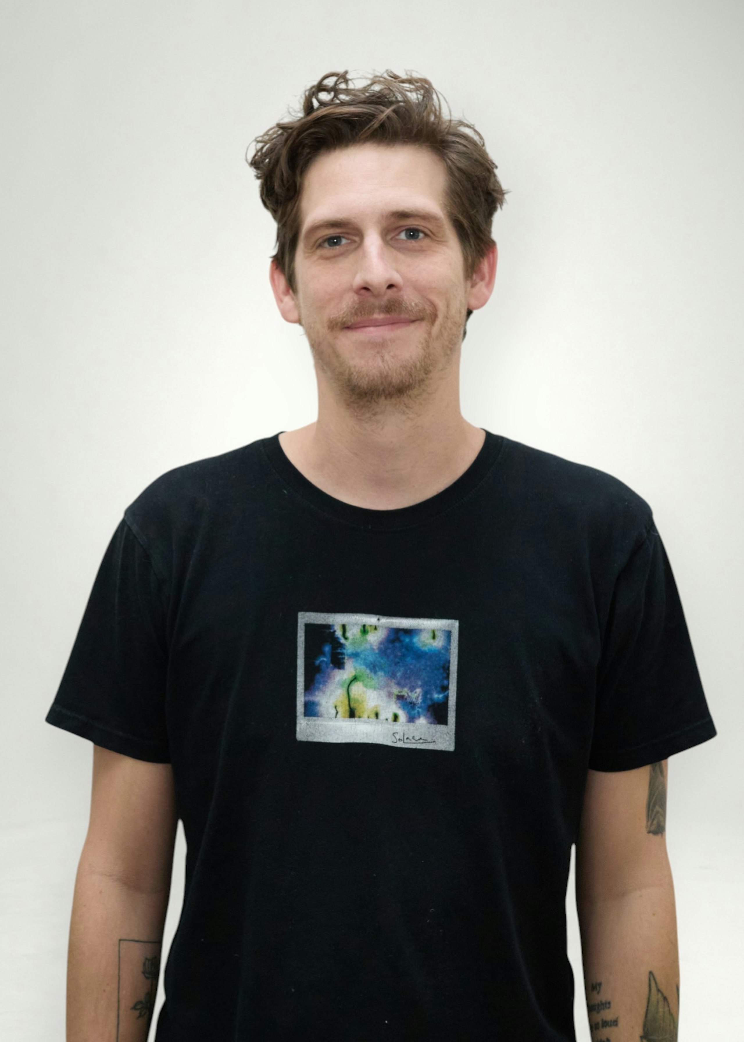 Sean poses in front of white background