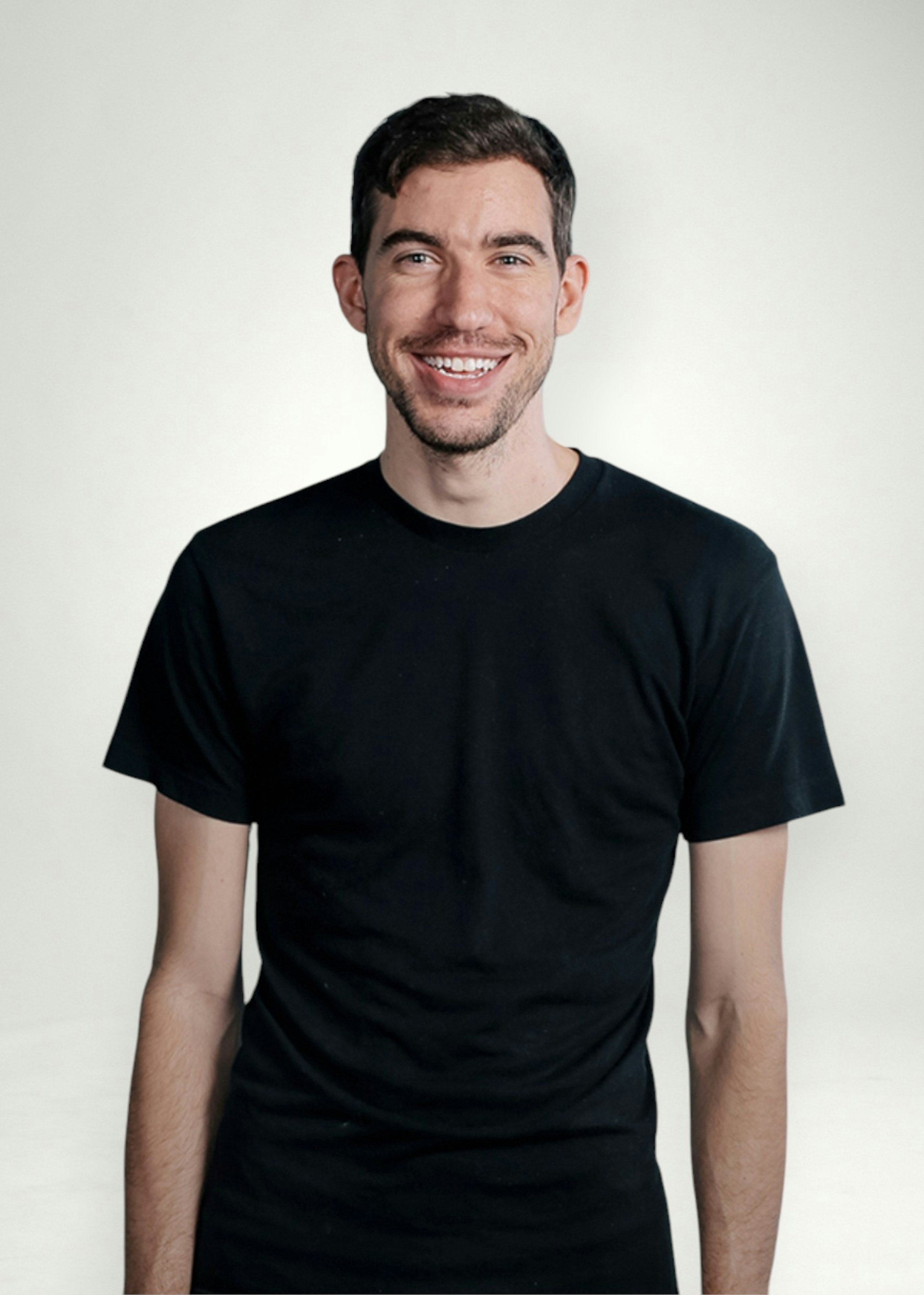 Nick poses in front of white background