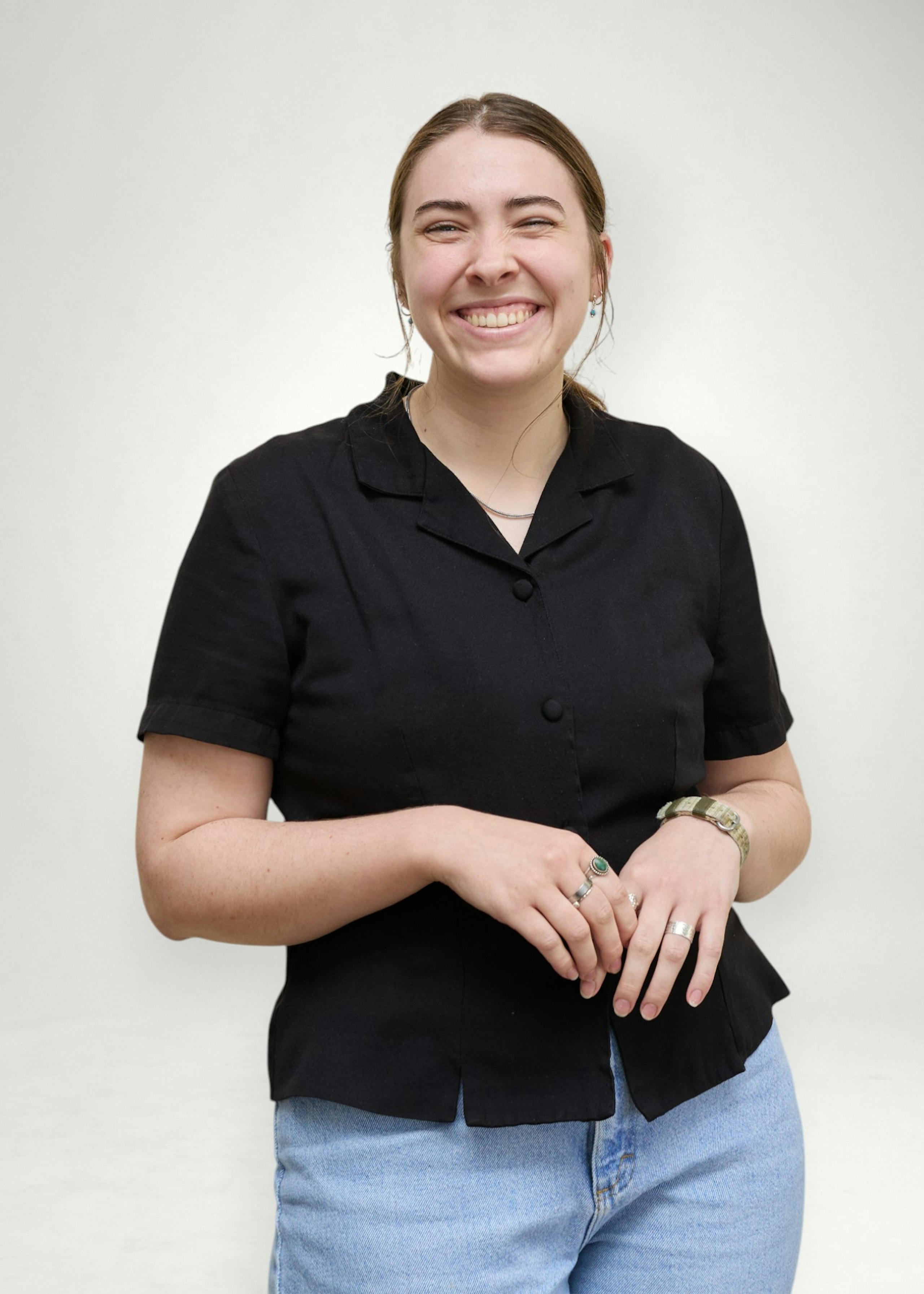 Tara poses in front of white background