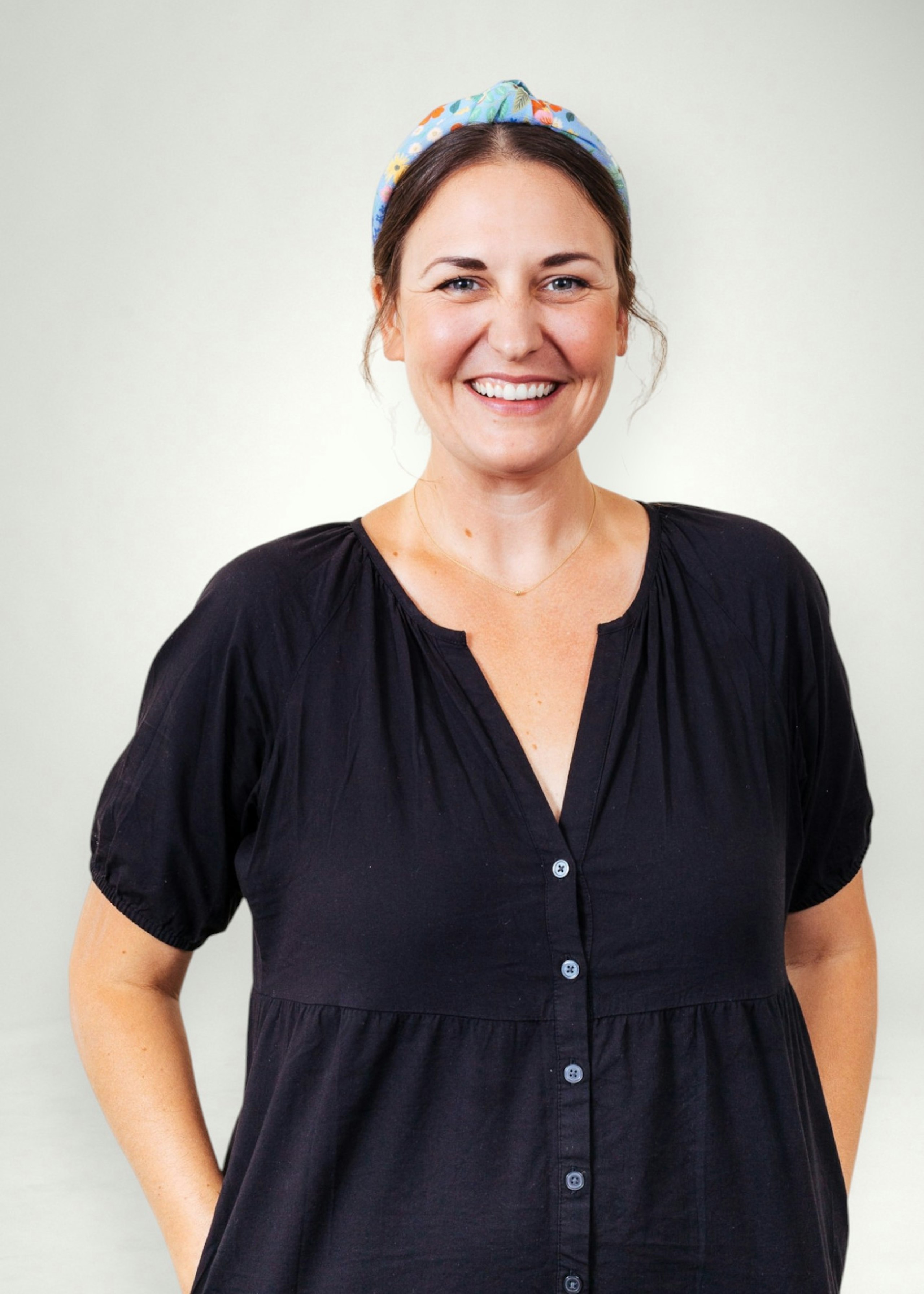 Sheryl poses in front of white background