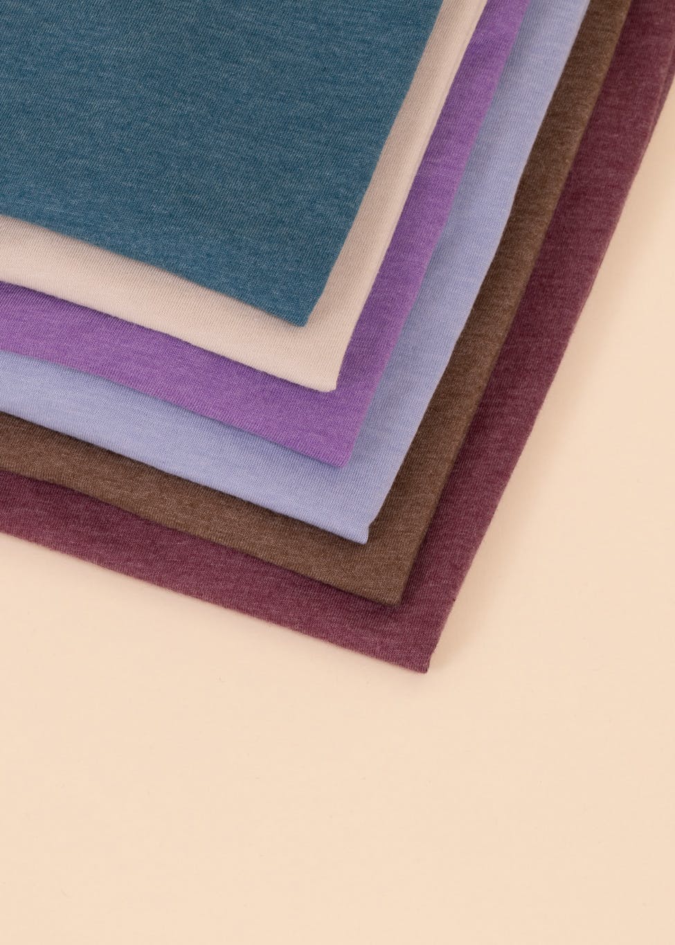close-up of t-shirts folded on a tan background