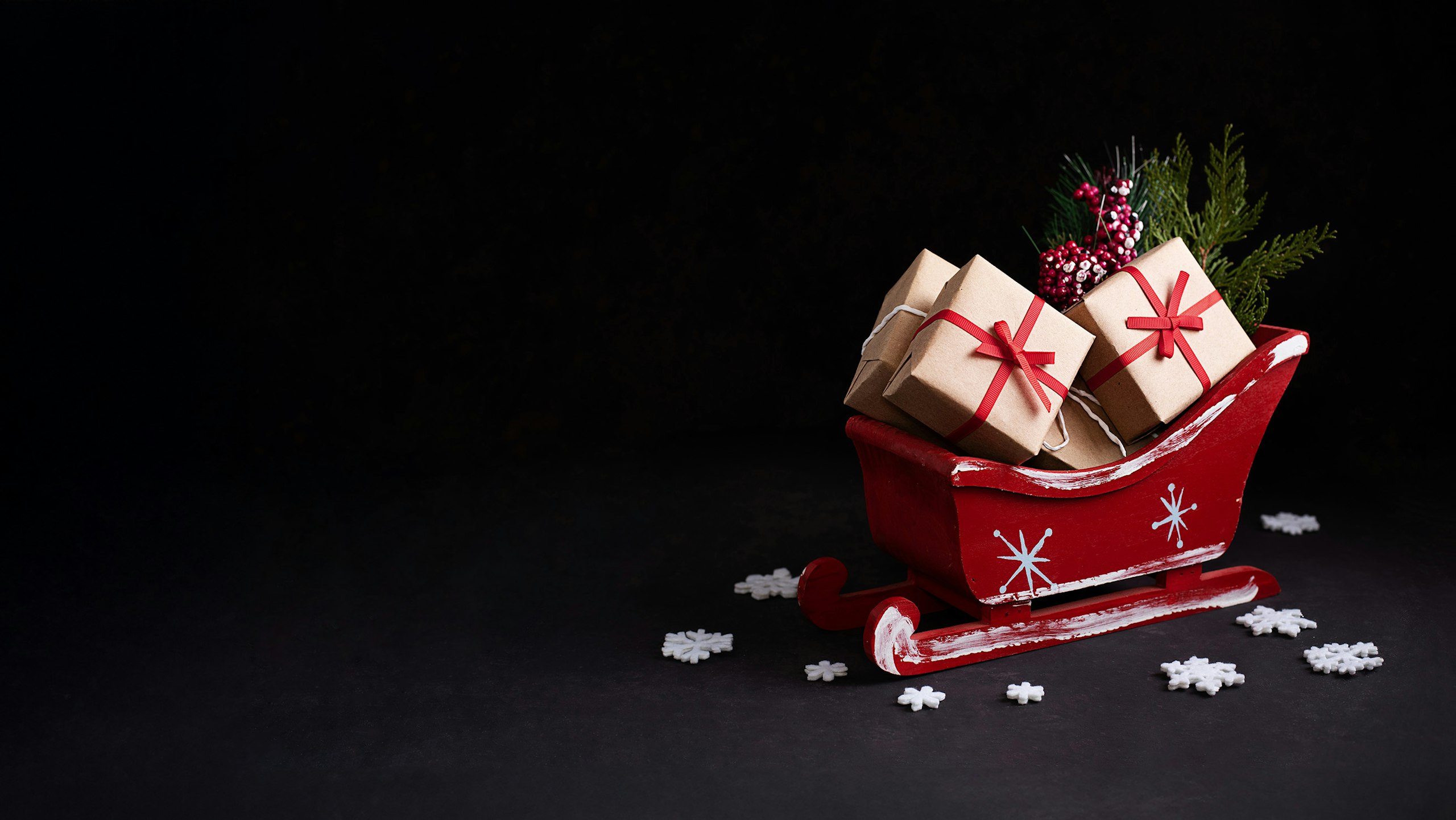 red sleigh with tan packages and a tree