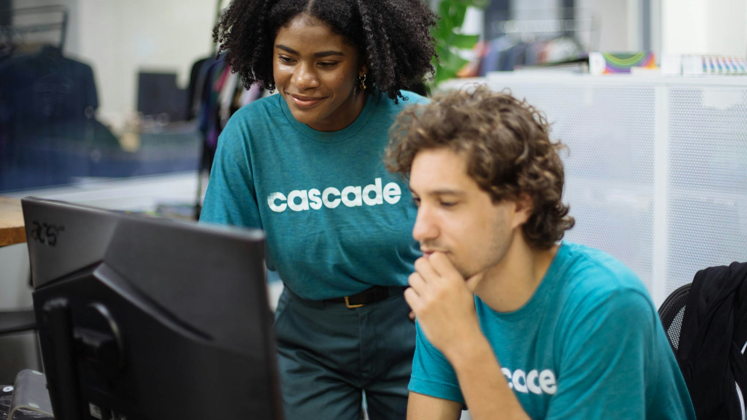 a women and man wearing teal t-shirts with the word cascade printed in white on them