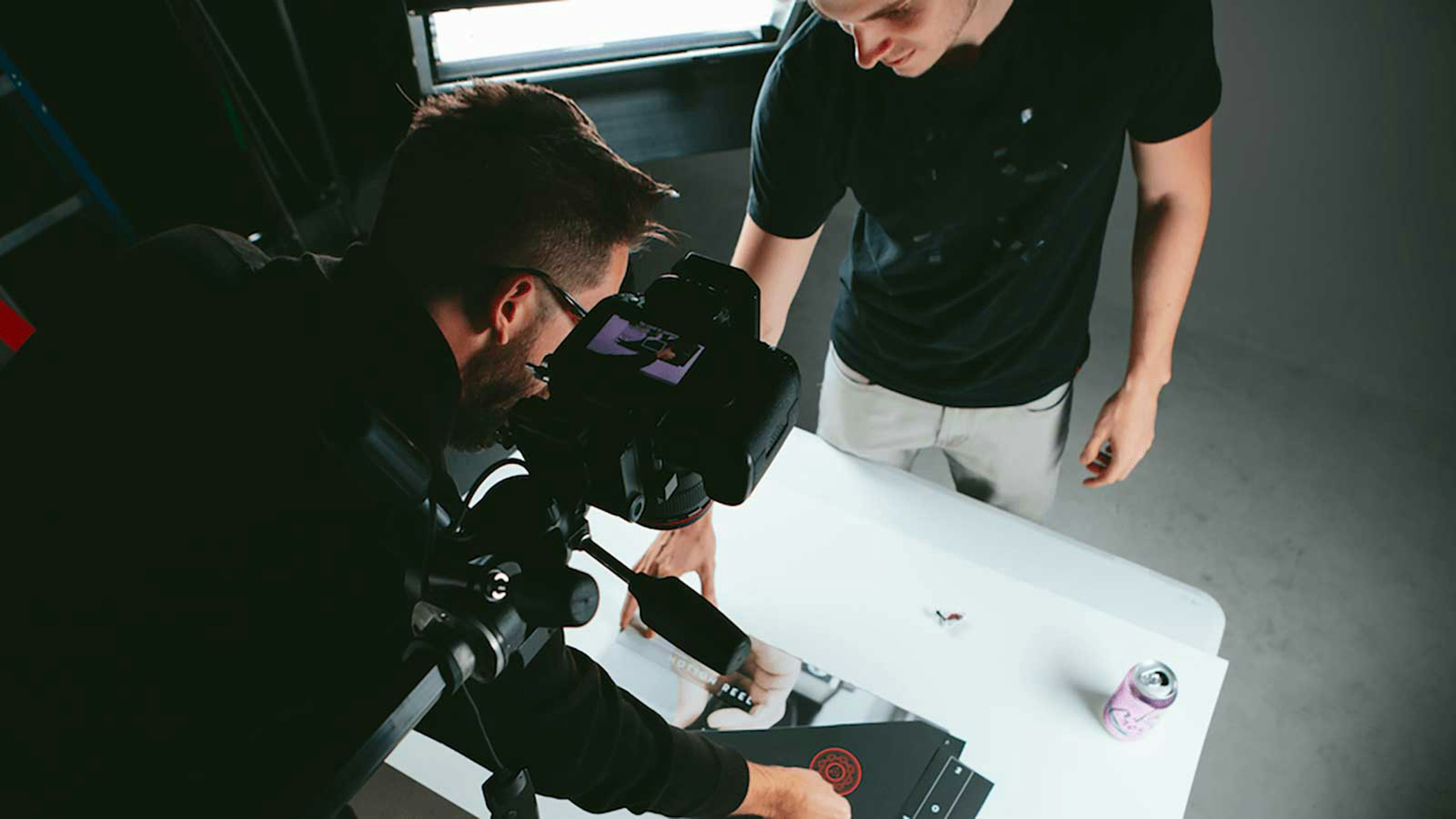 two guys taking overhead photos of a book