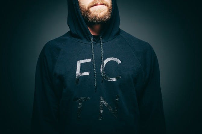 man wearing a black hoodie with black text printed on it