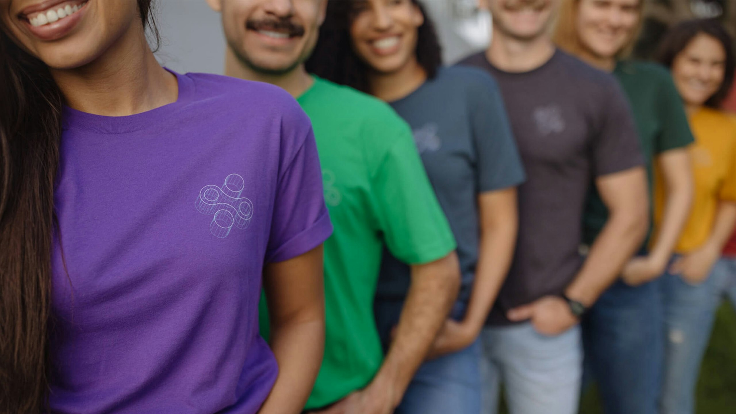 group of people lined up wearing different color tees