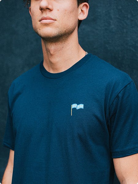 man wearing a blue t-shirt with a small logo in the top right