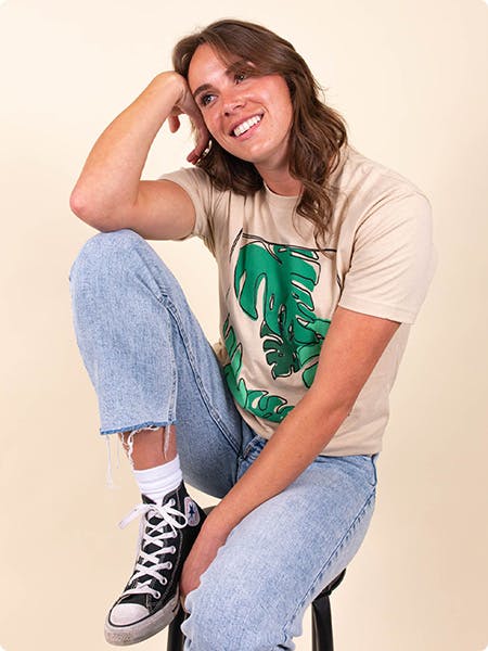 women wearing a tan tee with plant leaves printed on it