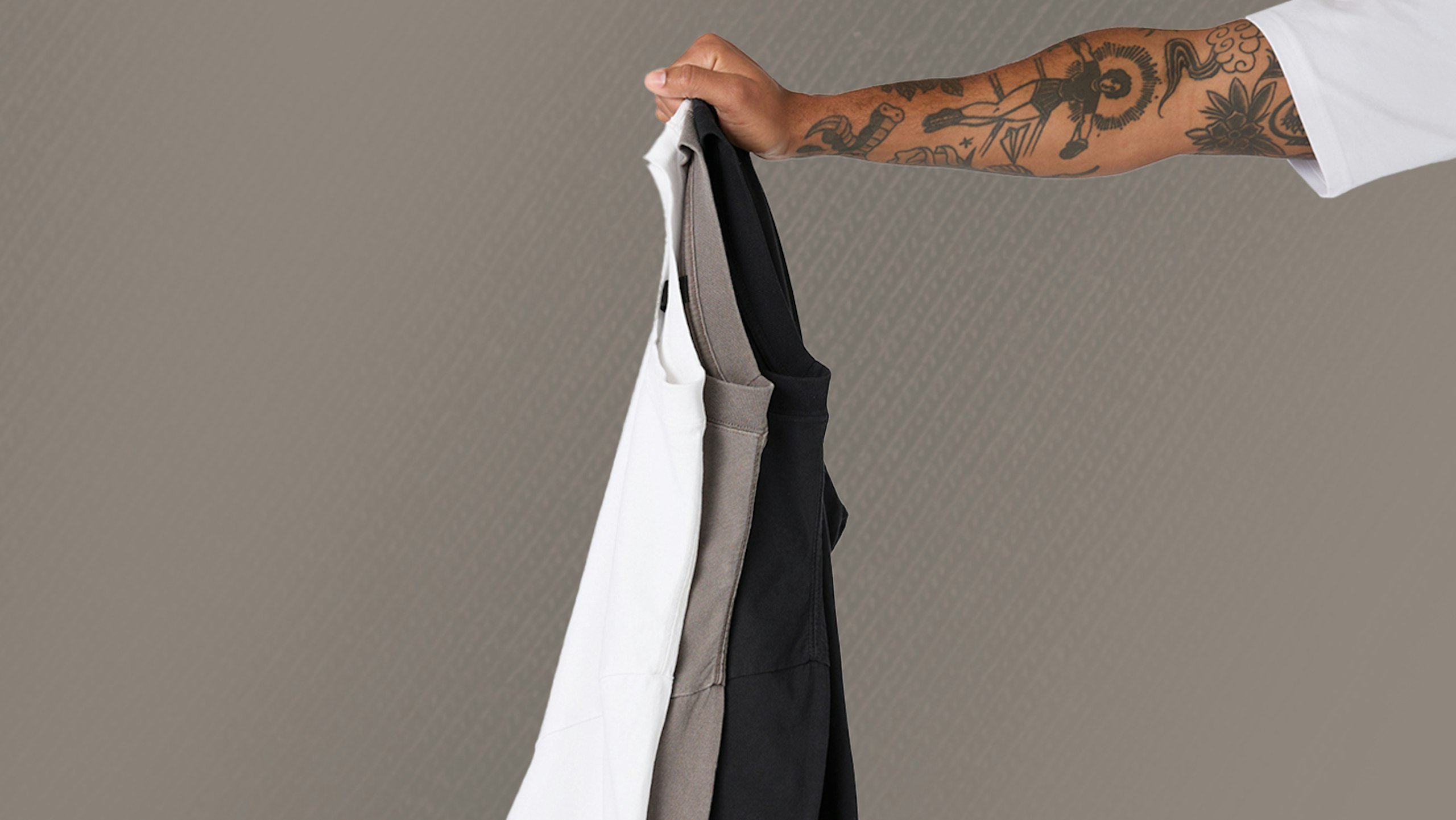 someone holding three t-shirts