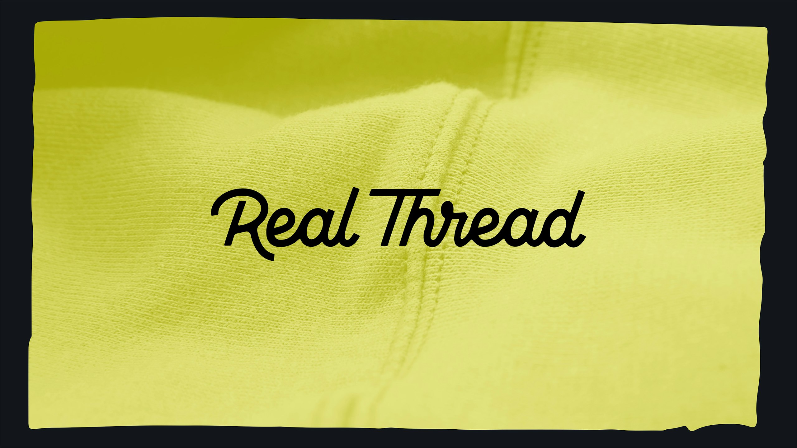 close up of yellow sweatshirt with real thread logo