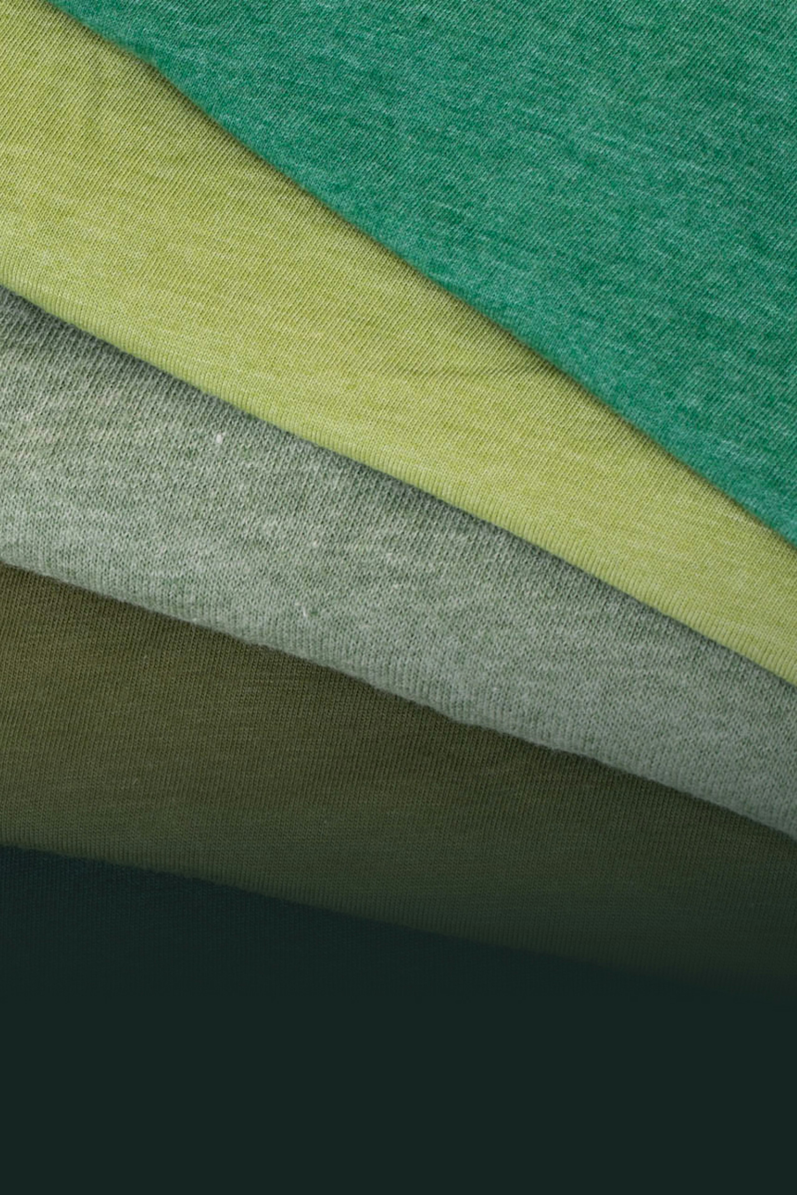 Green t-shirts folded fanned on top of each other