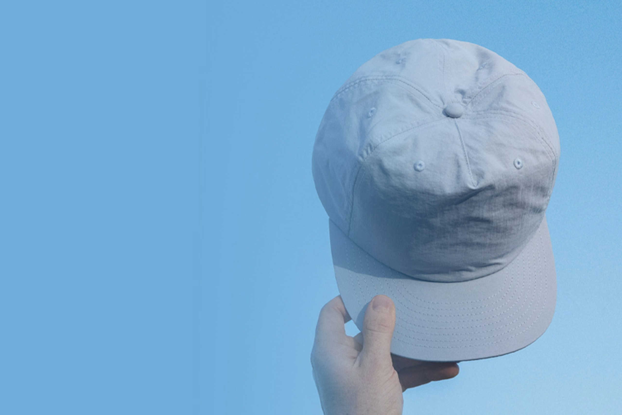 Someone holding a blue surf cap in the sky