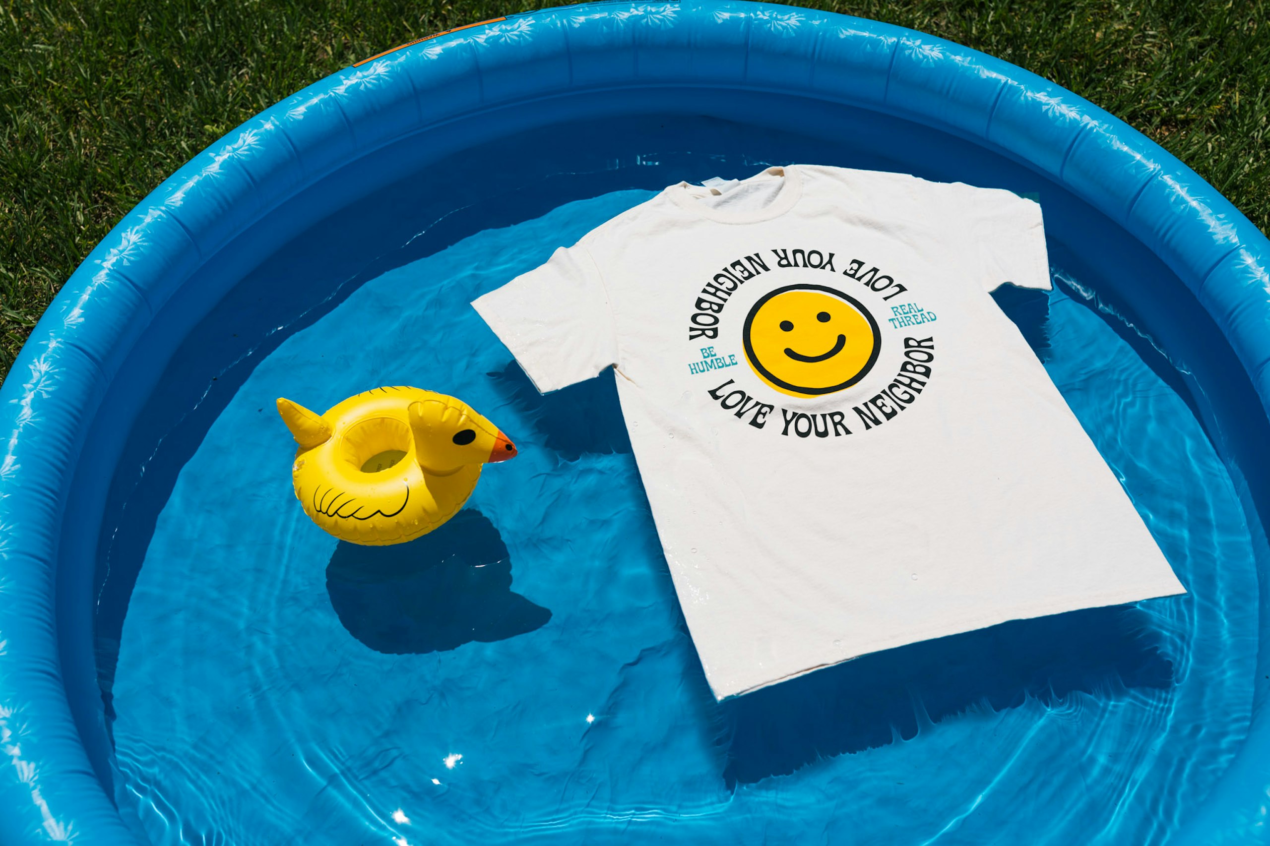 kiddy pool with a floating duck and t-shirt
