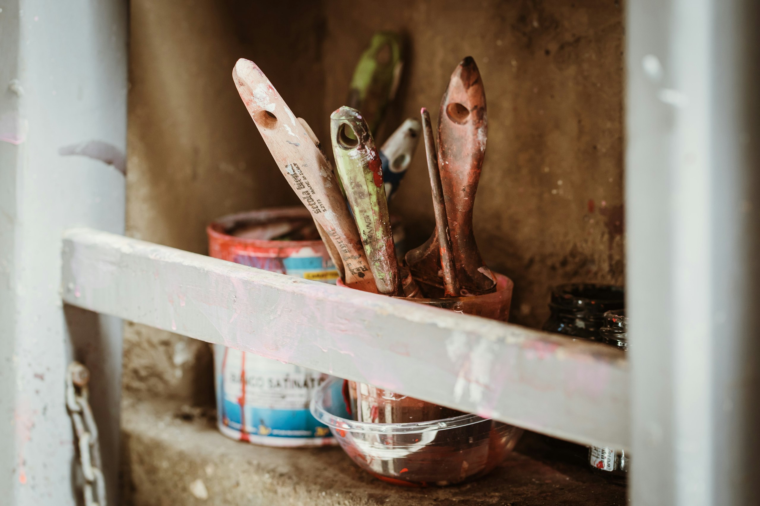 Paint brushes in a tin on a shelf
