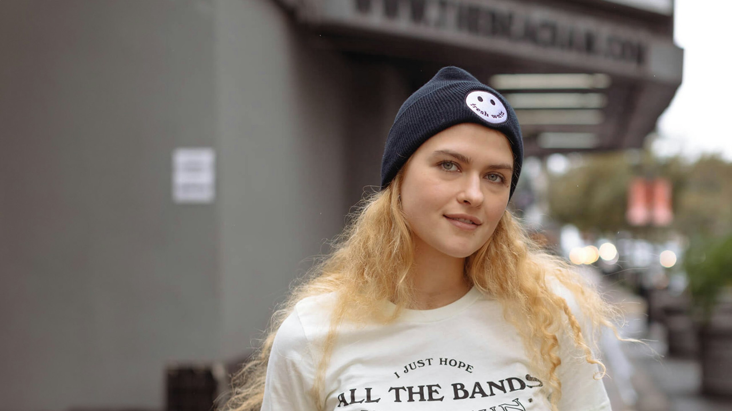 women wearing a black beanie hat with a smiley face patch