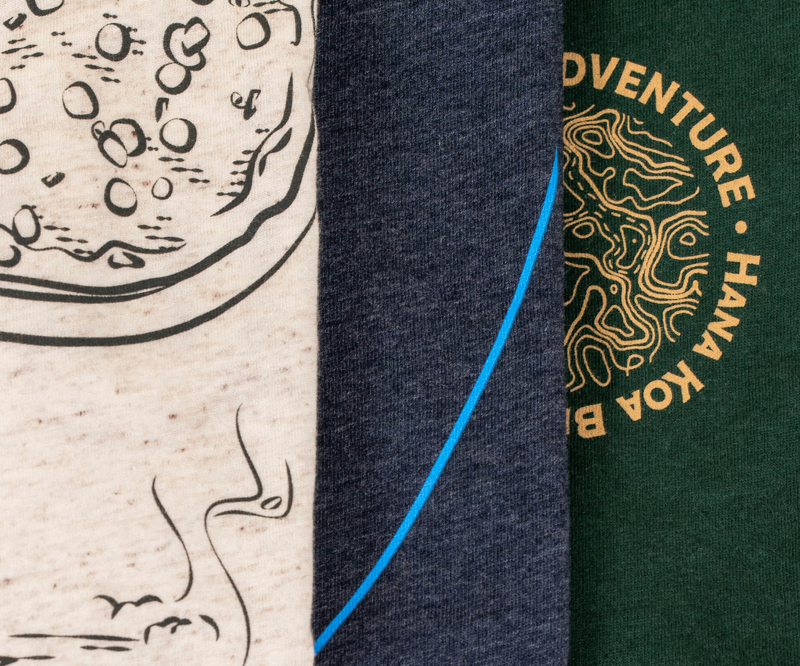 close up of three shirts, tan tri-blend, navy, and dark green
