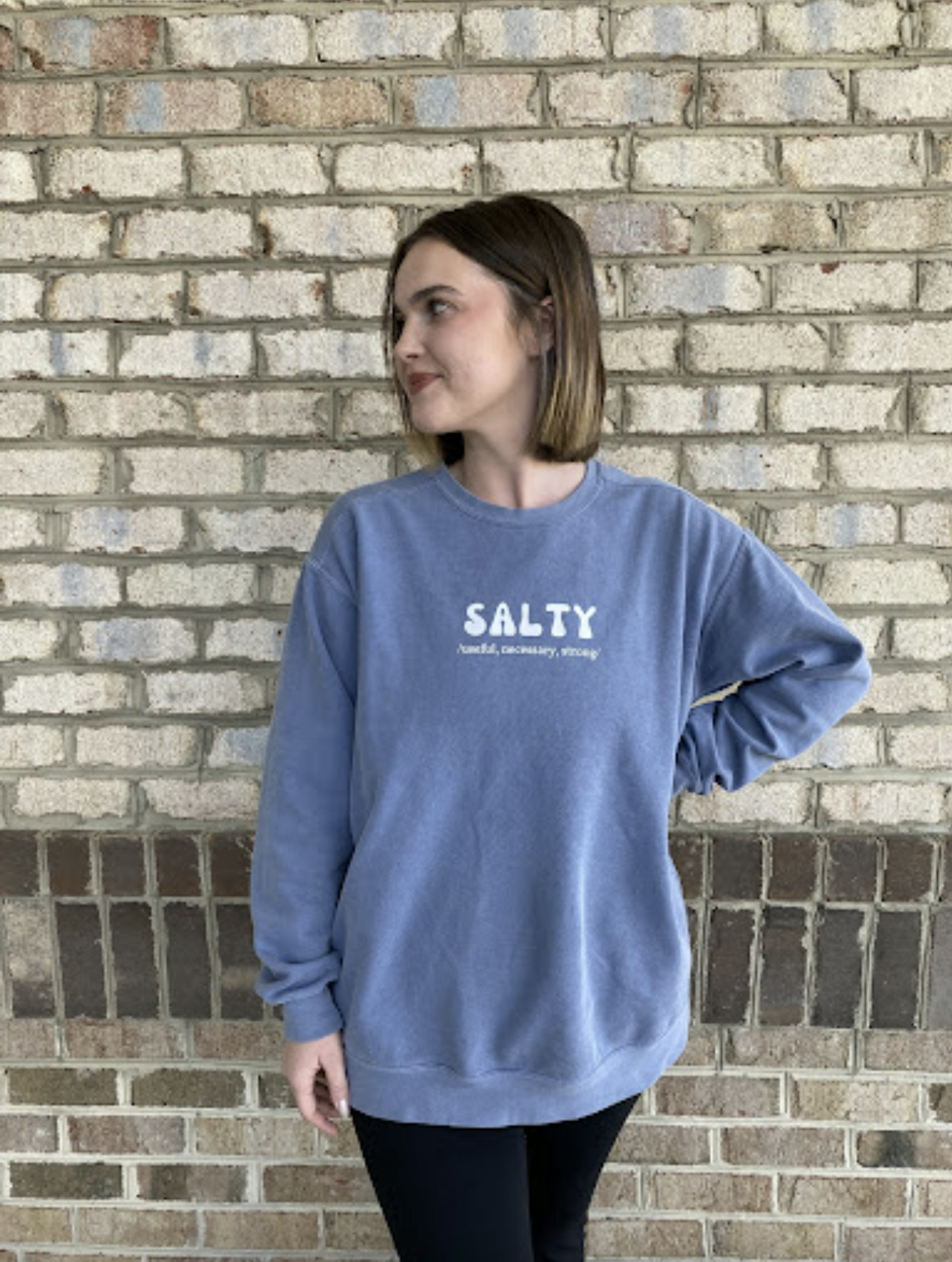 Girl wearing a blue sweatshirt that says "Salty"
