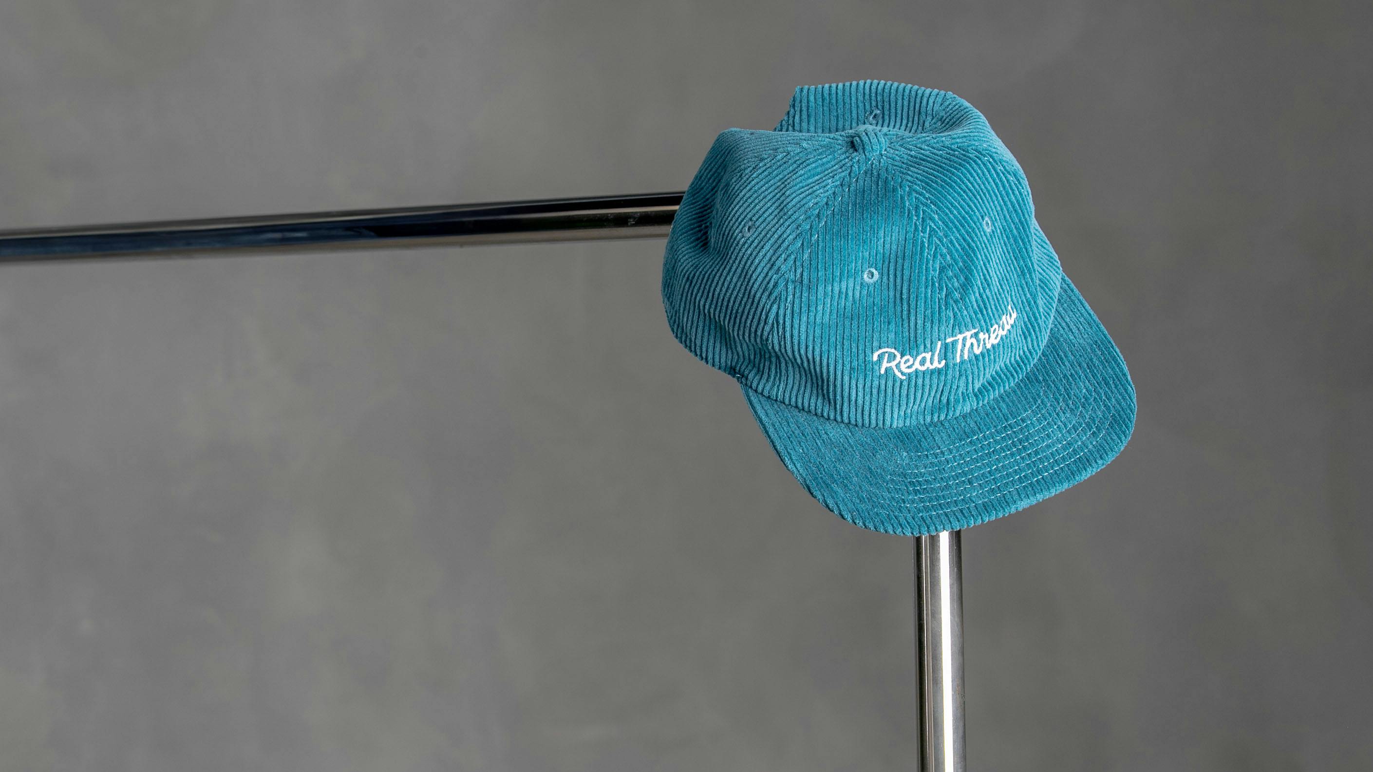 blue hat hanging on a clothing rack